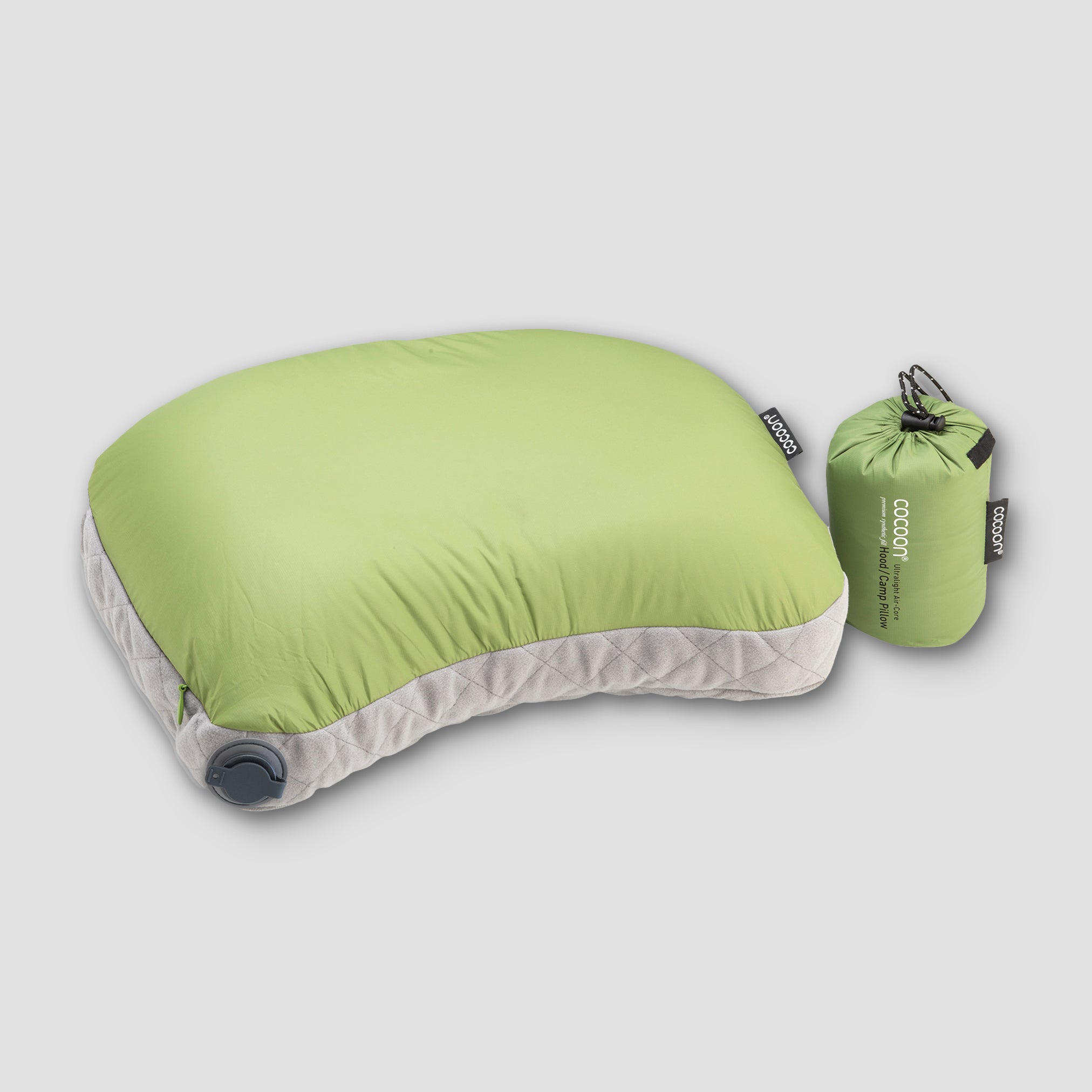 Green inflatable travel pillow with a carrying bag on a light gray background
