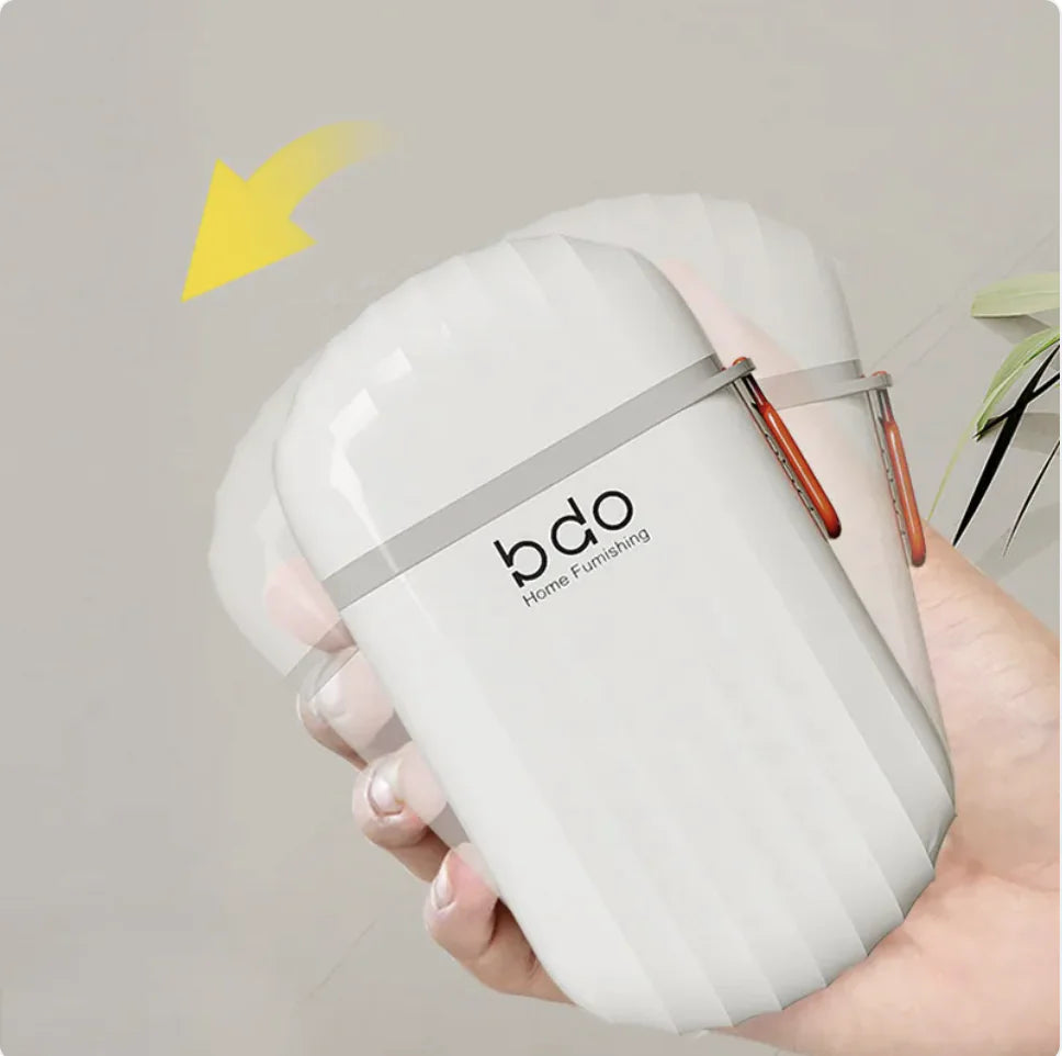 White decorative item with 'bdo' branding held by a hand against a neutral background