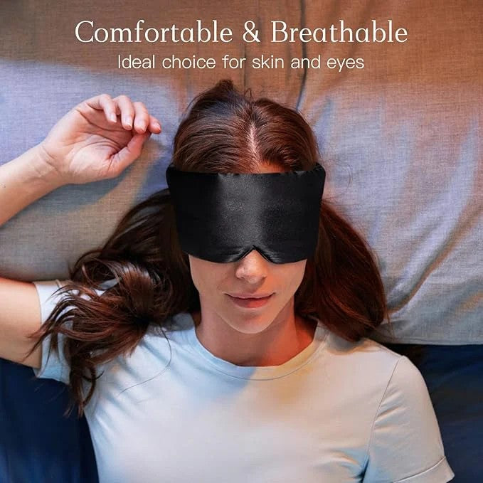 Person wearing a black sleep mask with text about comfort and breathability.