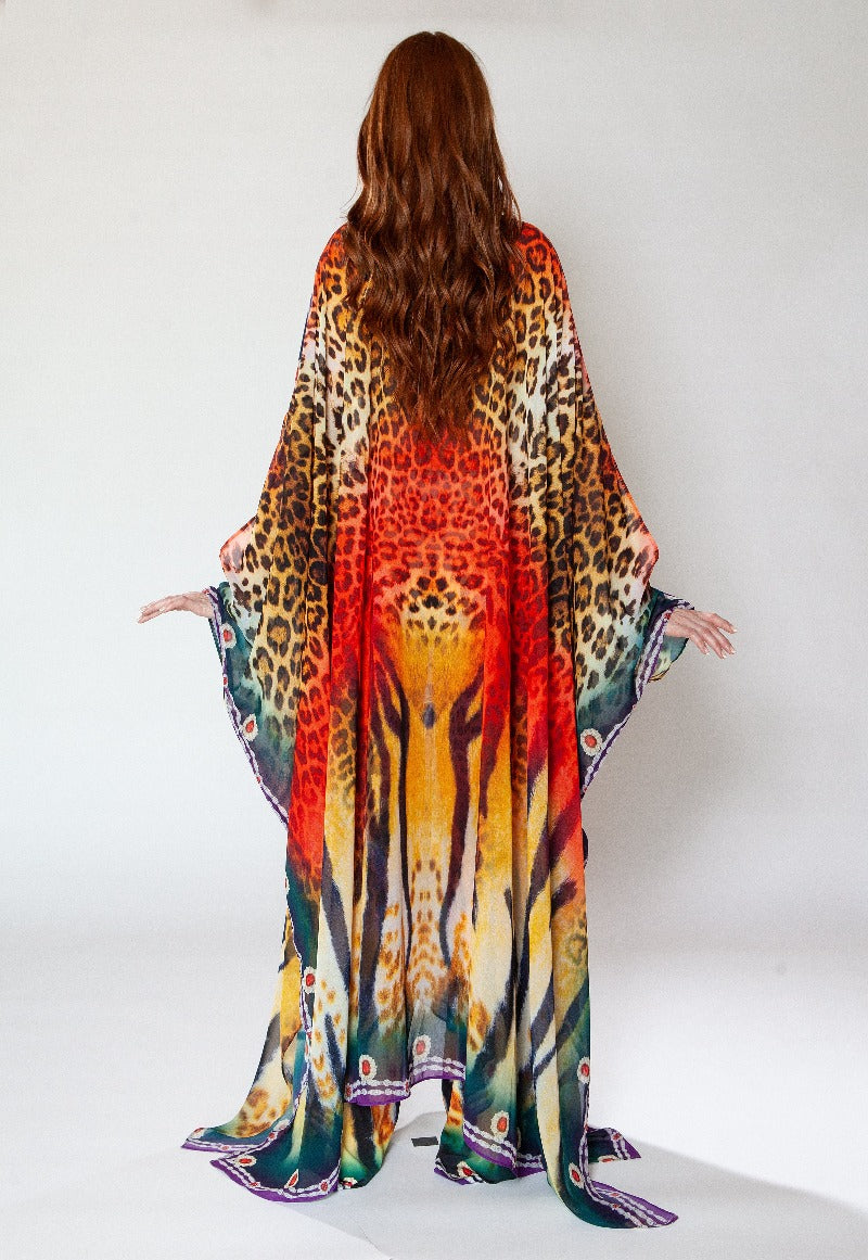 Woman wearing a colorful animal print dress against a white background