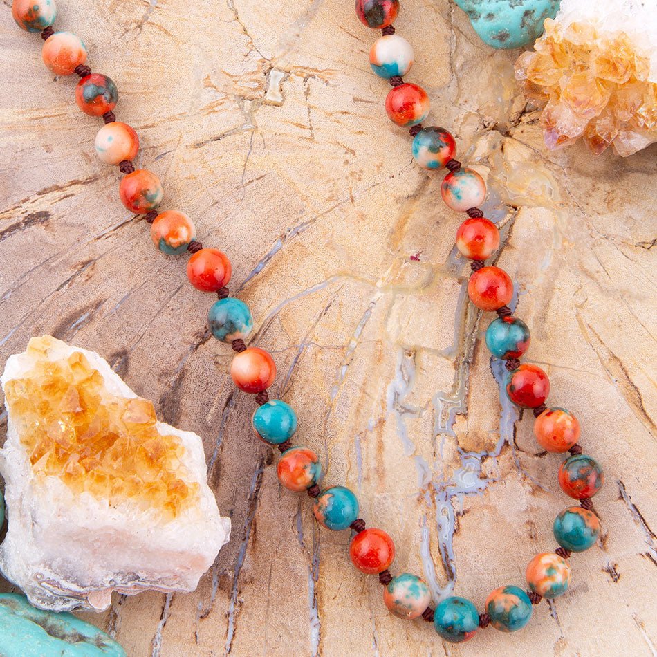 Necklace with multicolored beads on a textured surface with crystal rocks