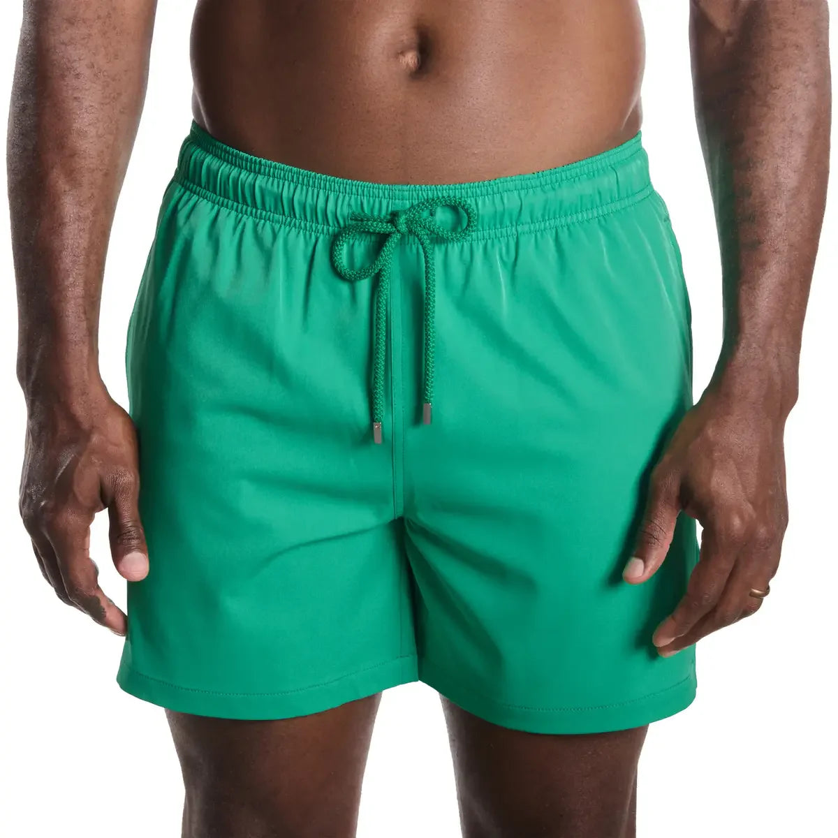 Green swim shorts worn by a person on a white background