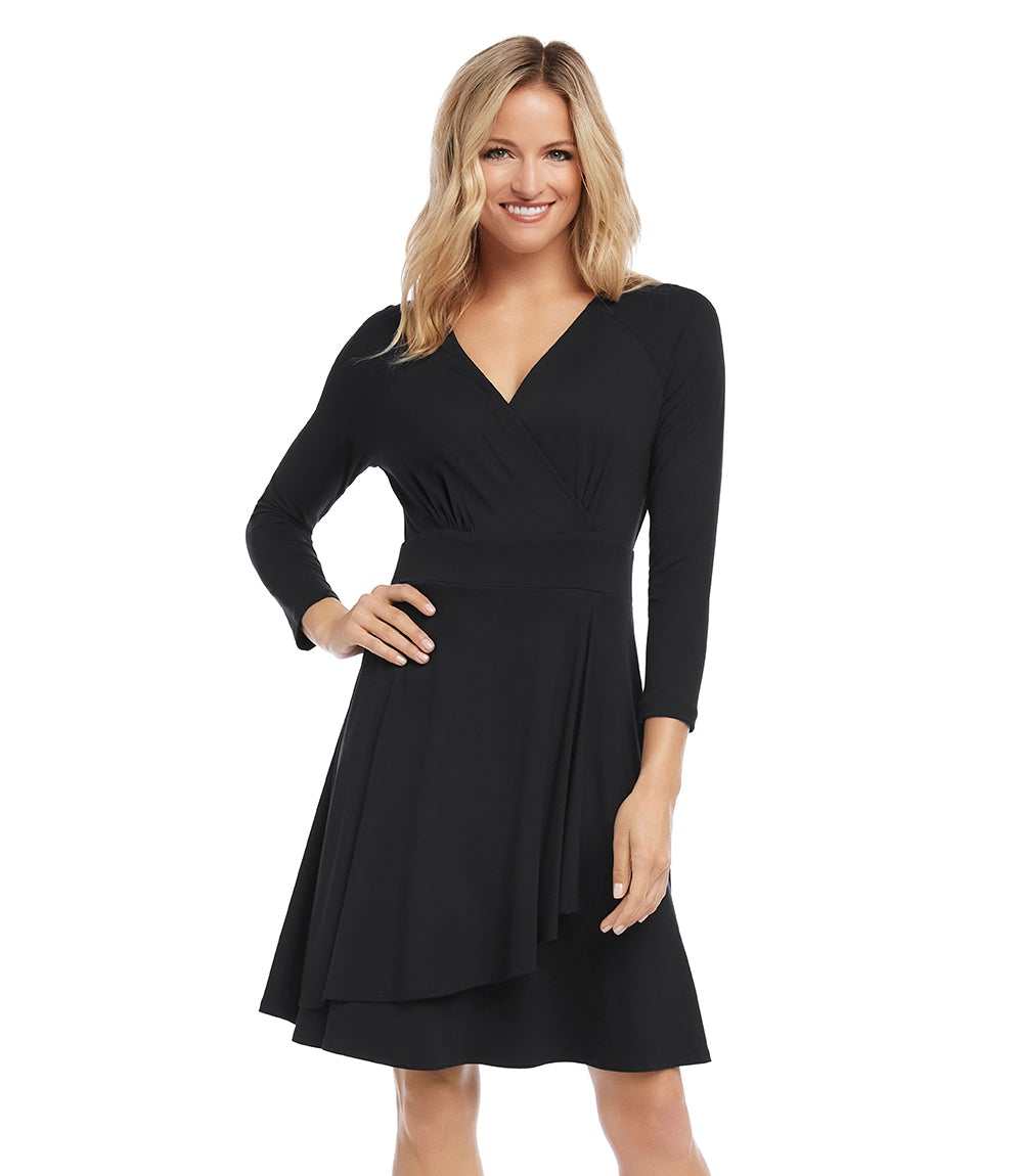 A woman modeling a black three-quarter sleeve V-neck dress with a flared skirt, photographed against a plain white studio background.