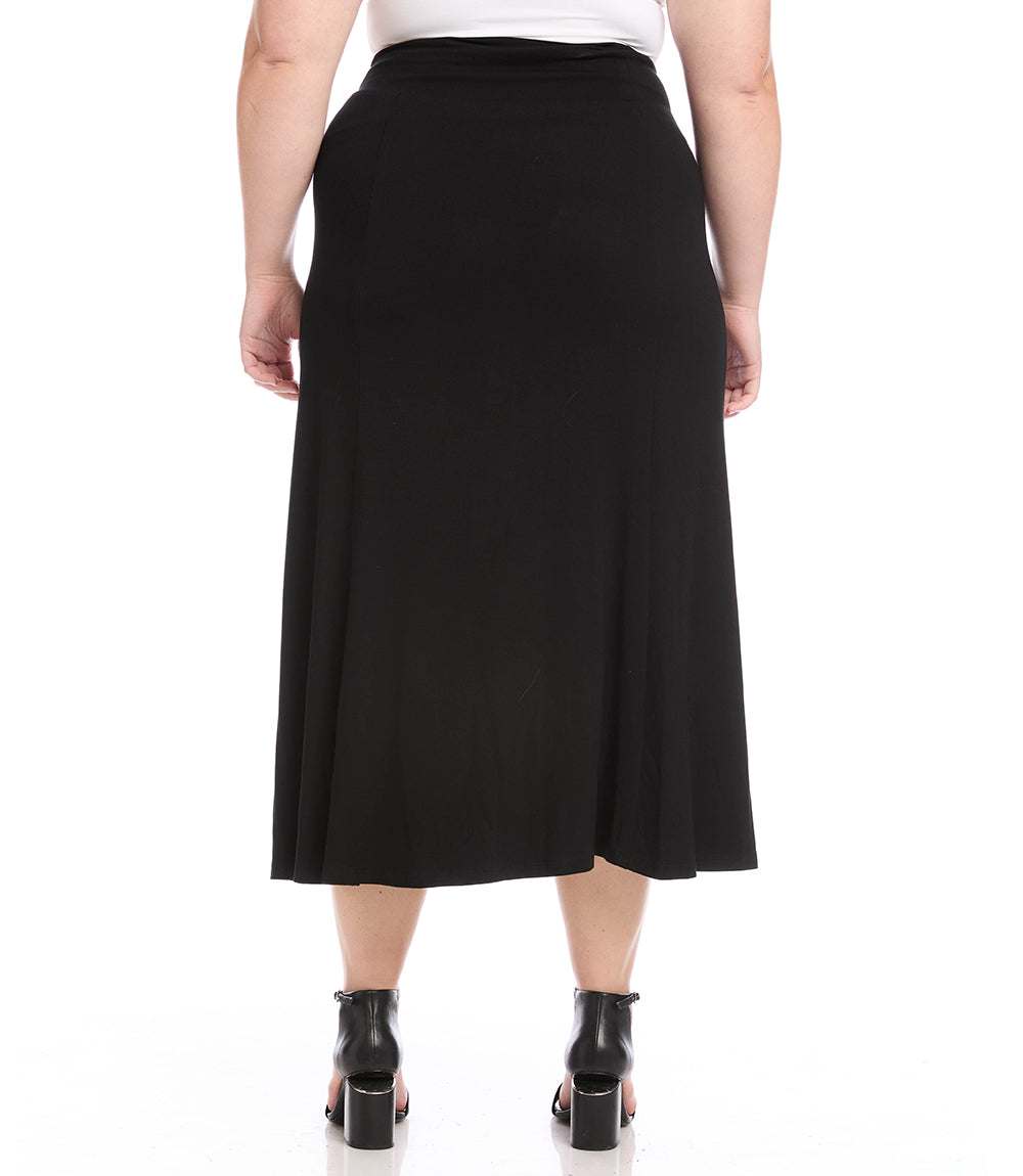 A black midi skirt shown from the back on a model, paired with a white top and black ankle boots, against a plain white background.