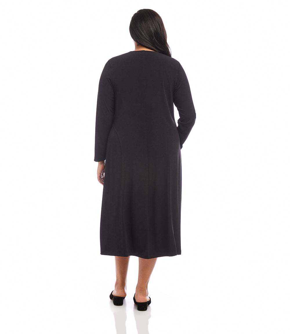 A woman viewed from the back wearing a long-sleeve black midi dress with side pockets, paired with black flat shoes, against a plain white background.