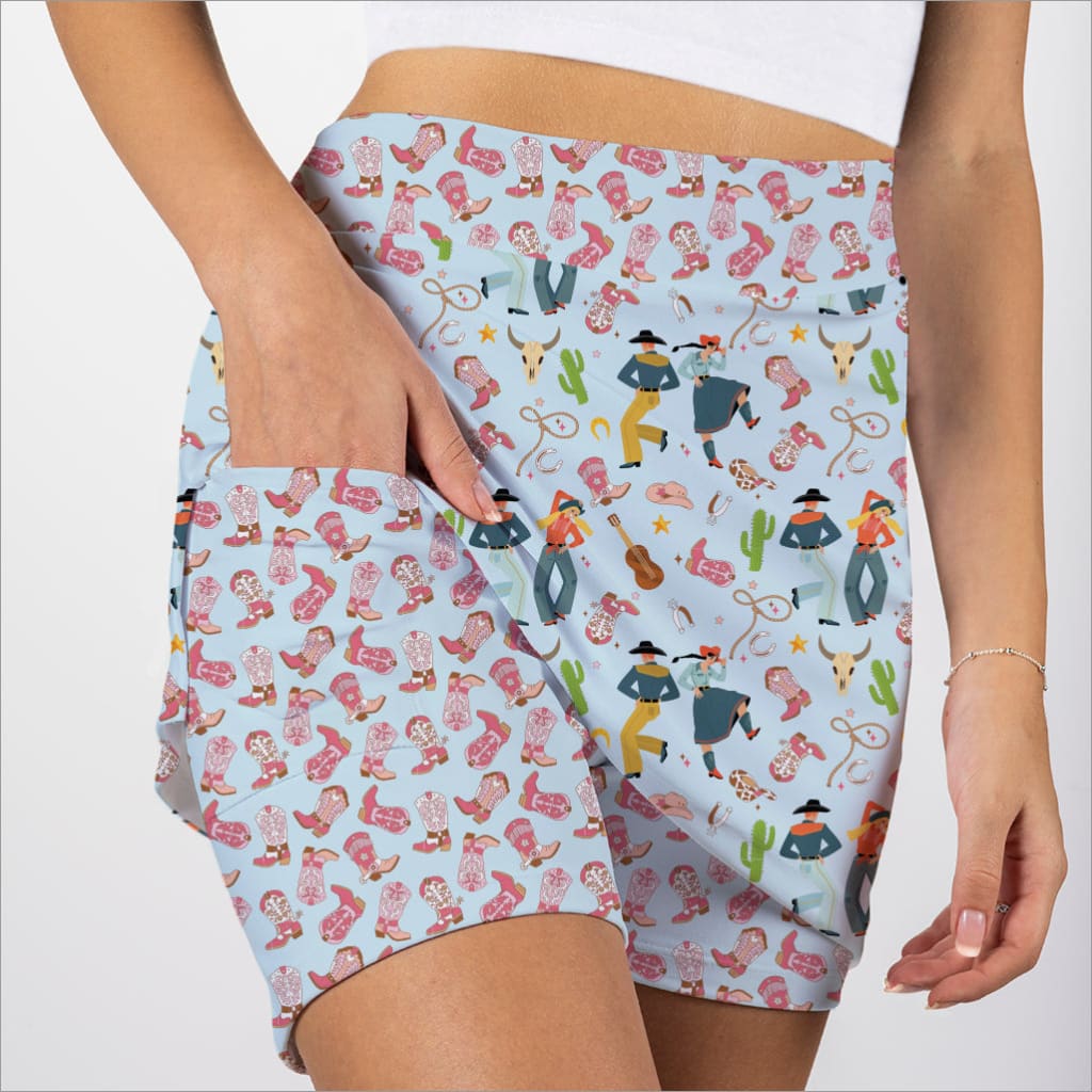 Shorts with a colorful pattern of people and cacti on a light blue background