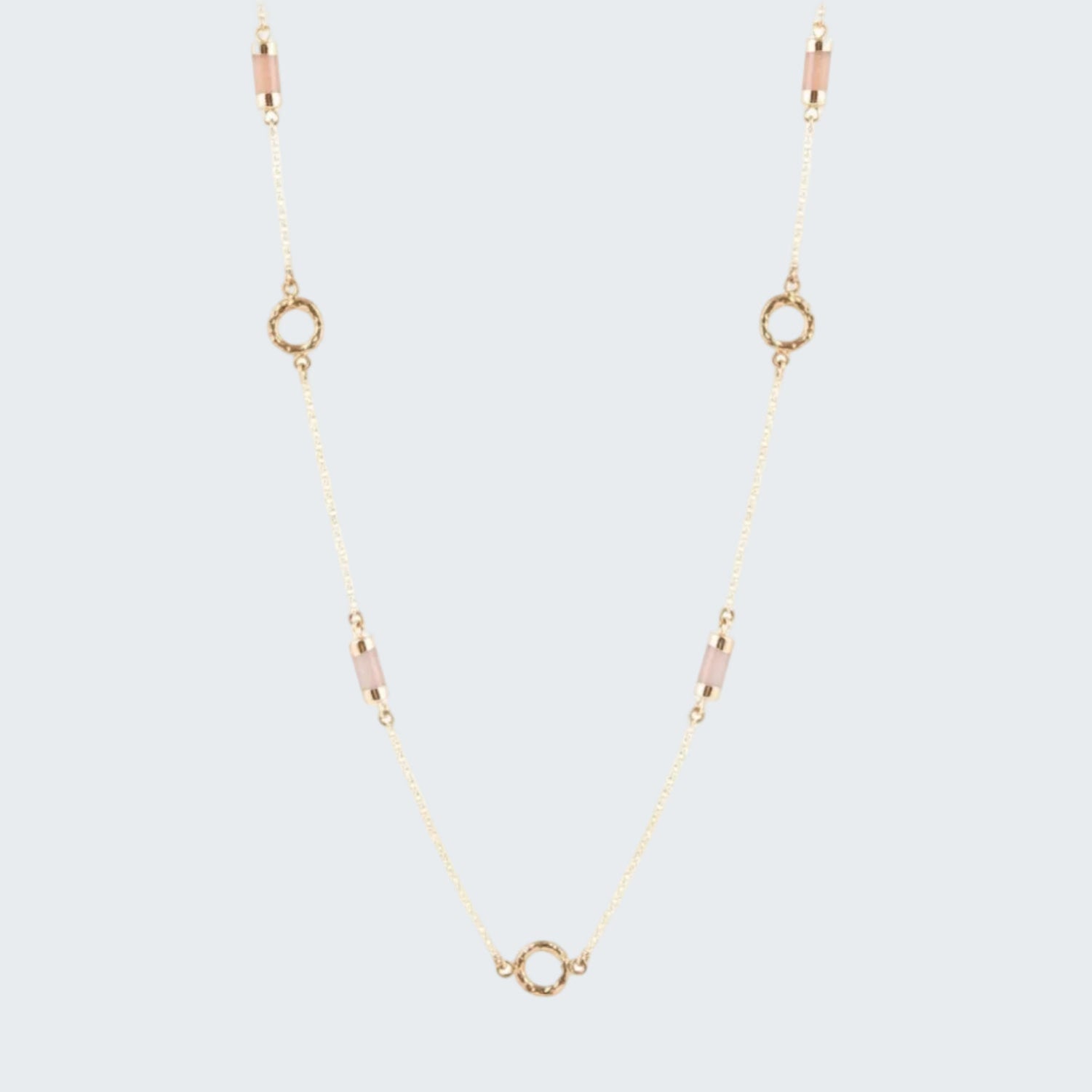Gold necklace with small circular pendants on a white background