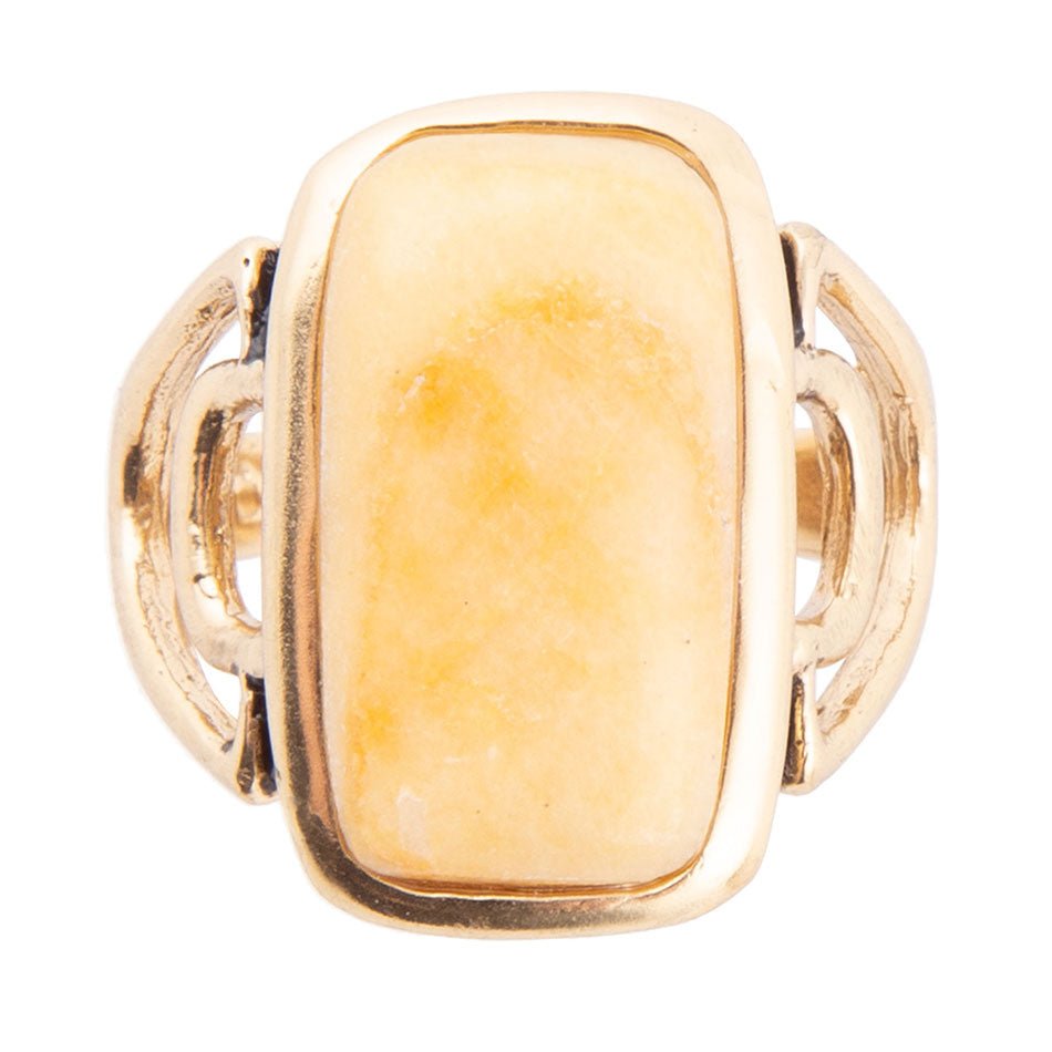 Gold ring with a yellow stone on a white background