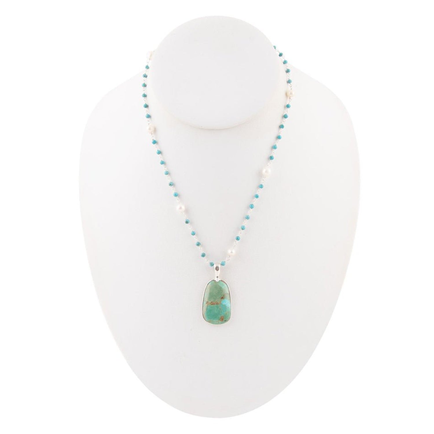 Necklace with turquoise pendant on a white stand