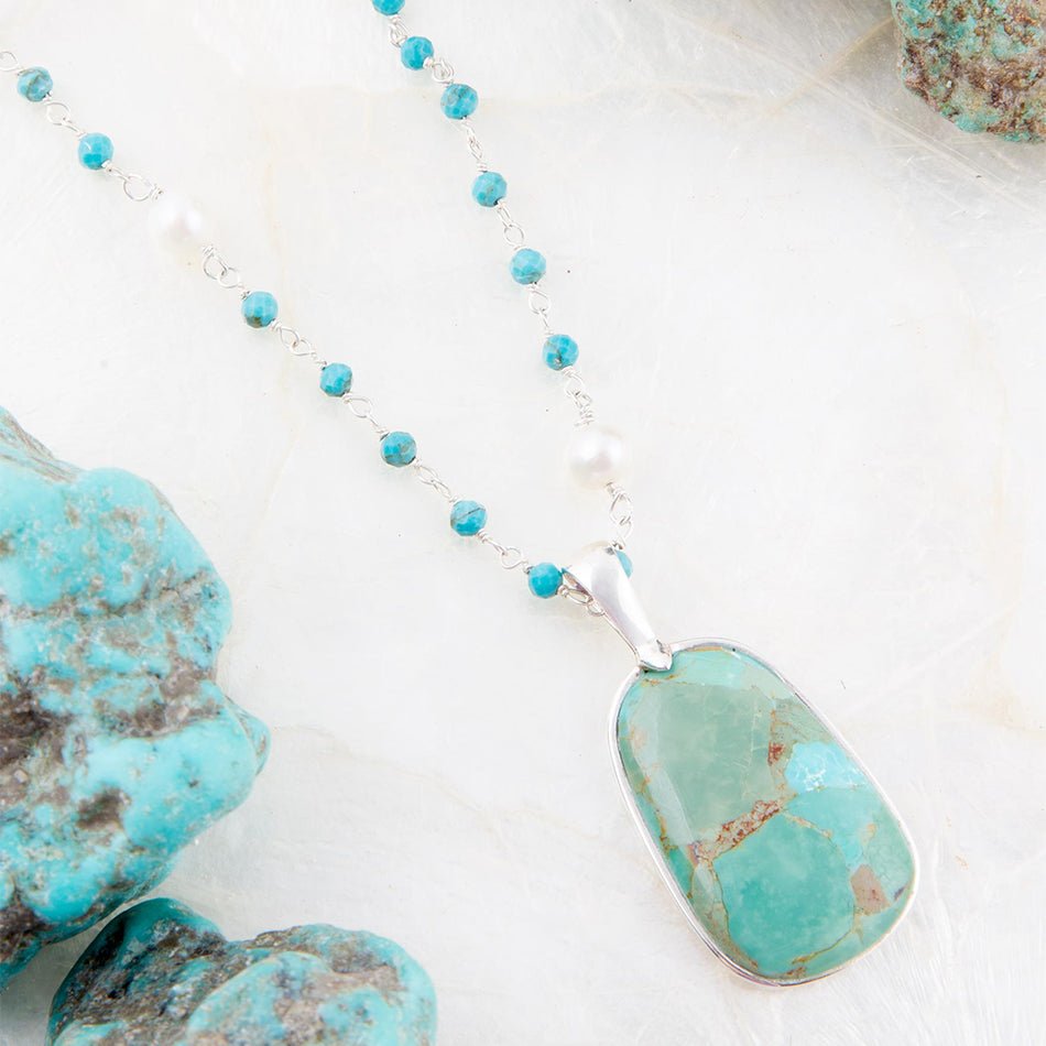 Turquoise necklace with pendant on a light background