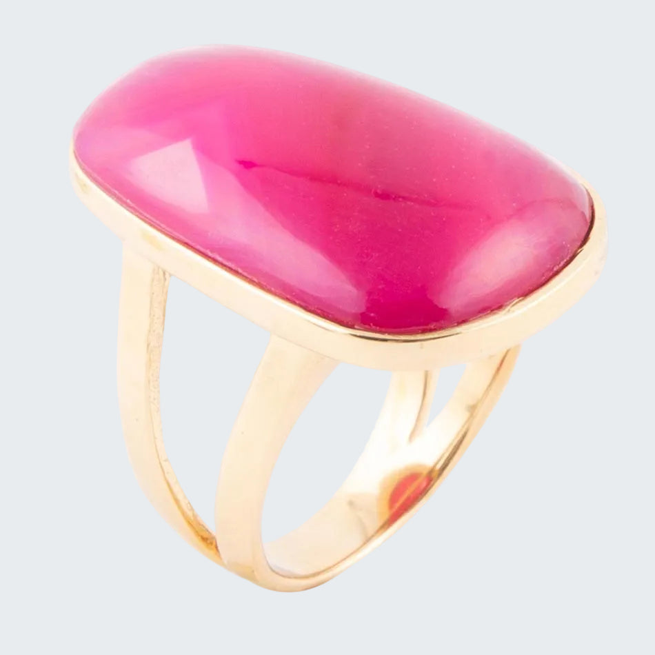 Gold ring with a pink stone on a white background
