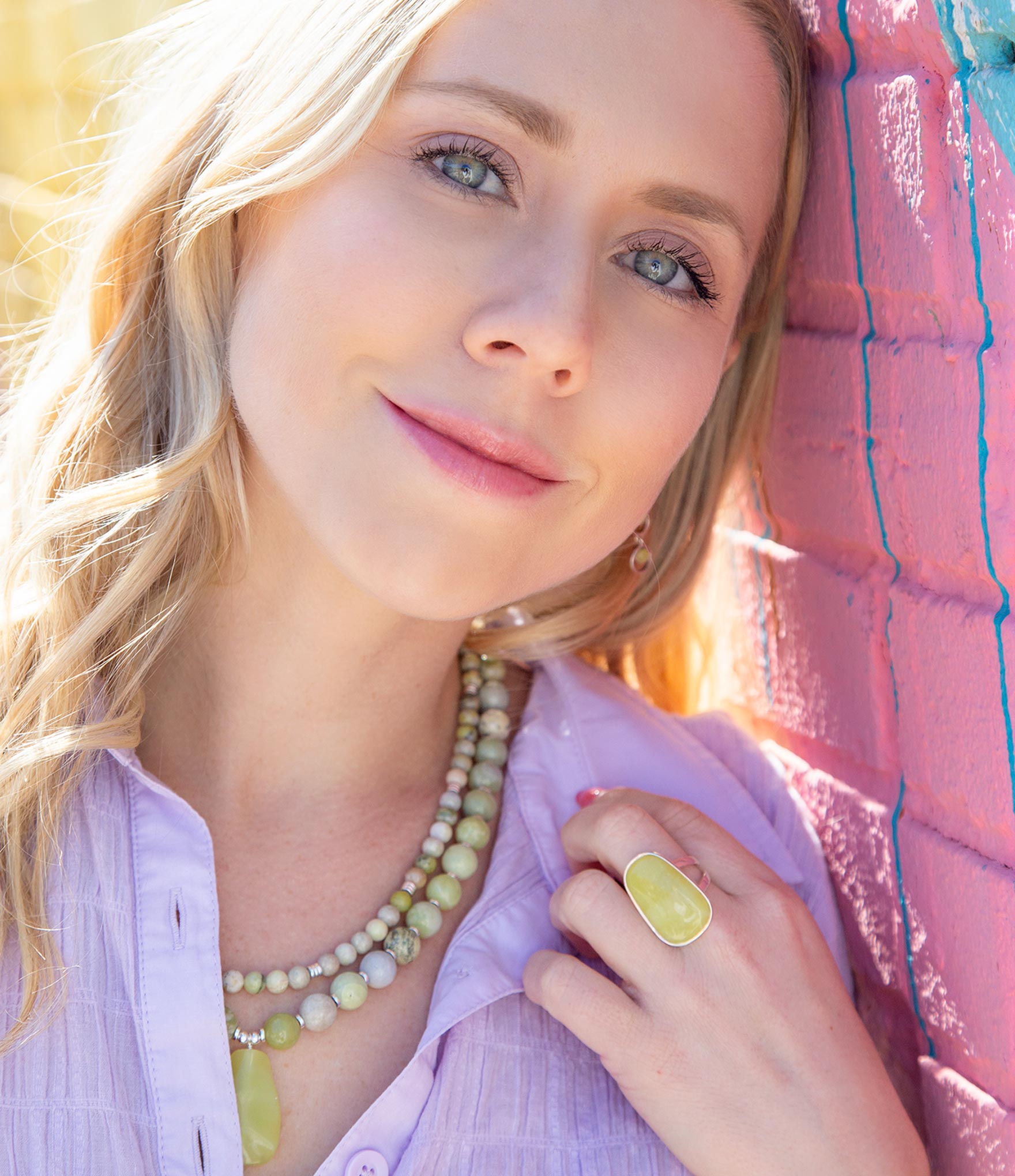 Woman wearing a necklace and ring with a colorful background