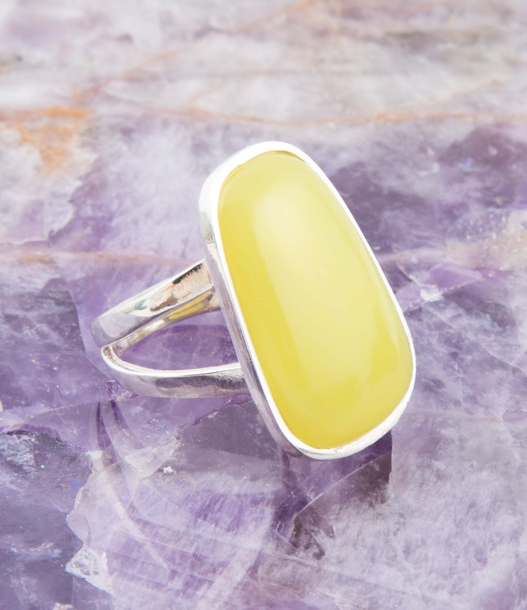 Ring with a yellow stone on a purple crystal background