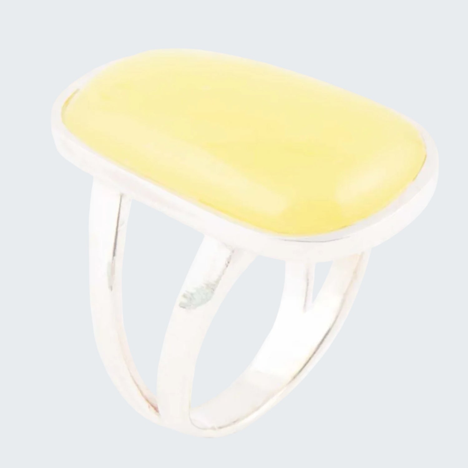 Ring with a yellow top and clear band on a white background