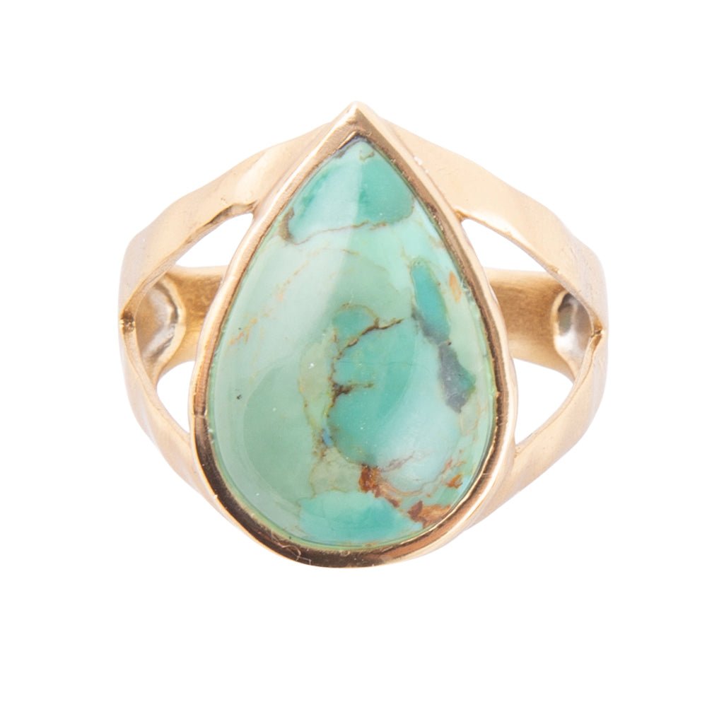 Gold ring with a large turquoise stone on a white background