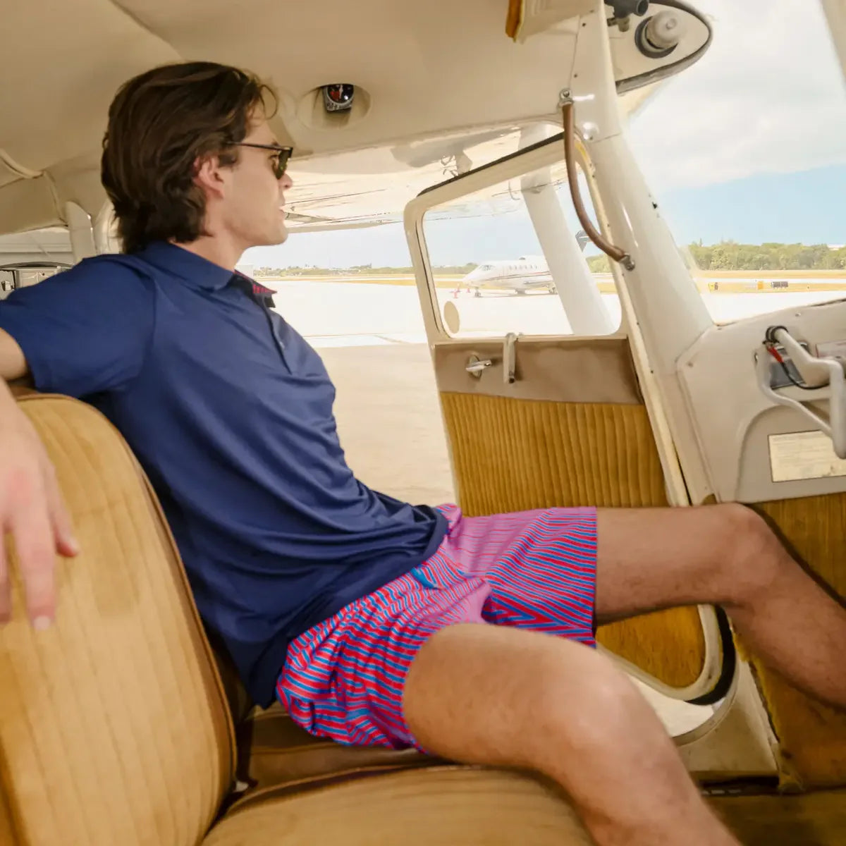 Man sitting inside a small airplane with a scenic background