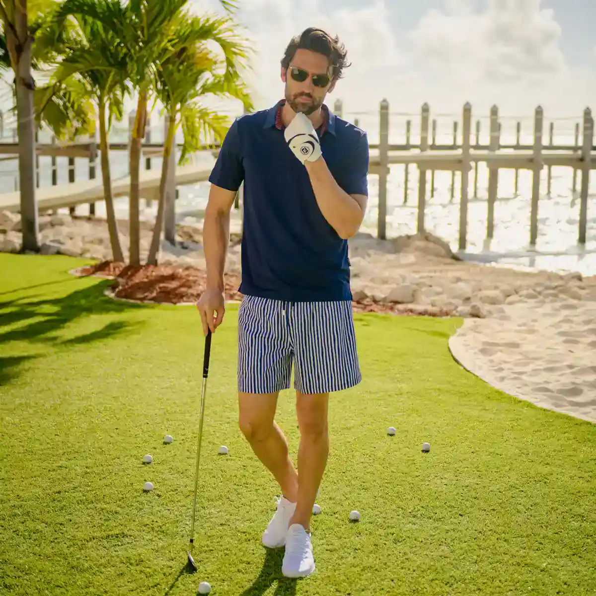Man playing golf on a sunny day by the water