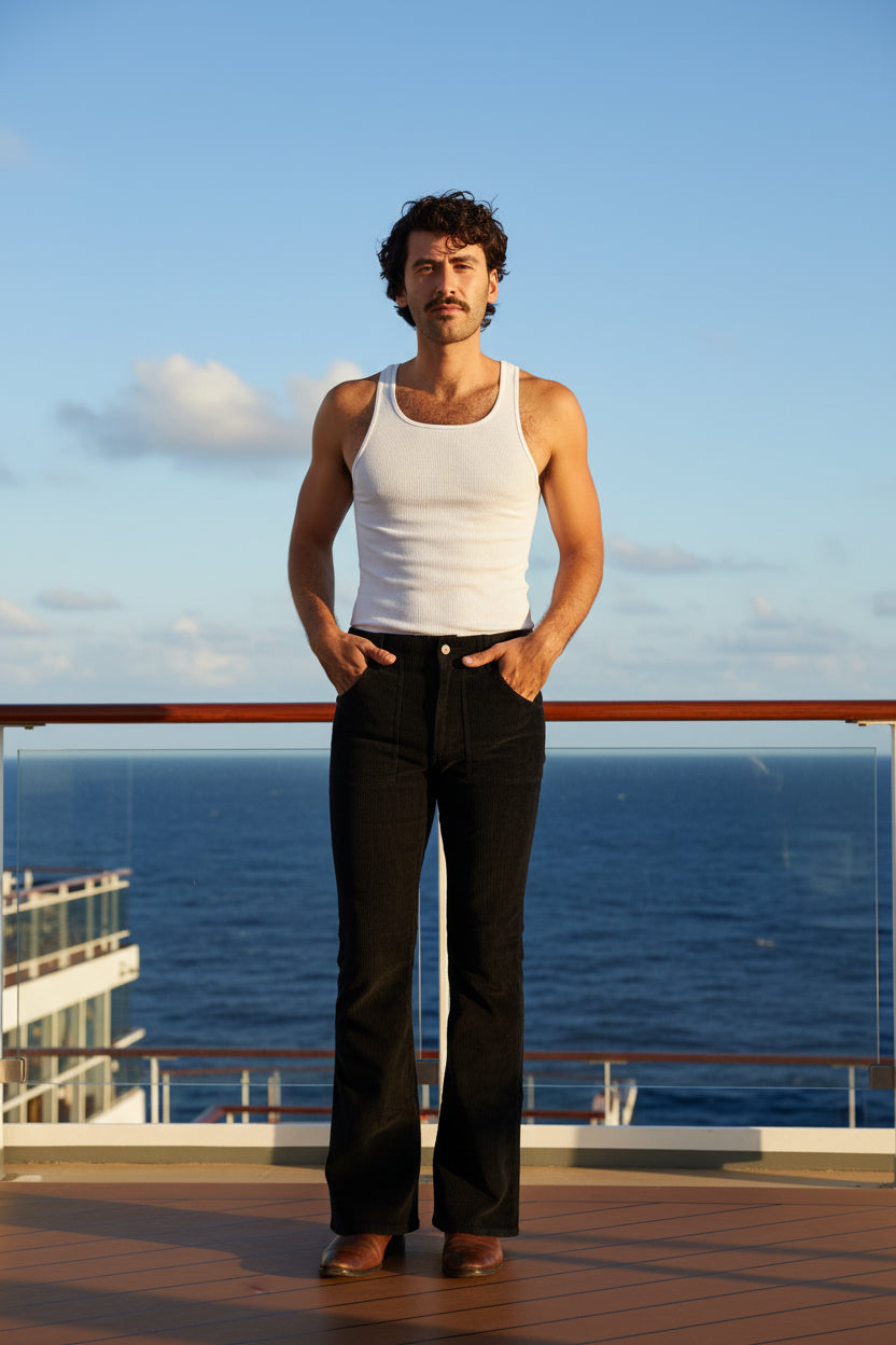 Man wearing a white tank top and black pants on a white background