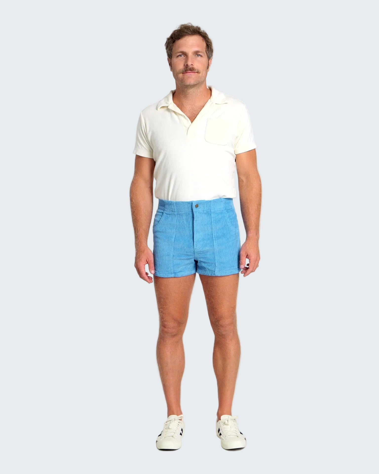 Man wearing a white polo shirt and blue shorts on a white background