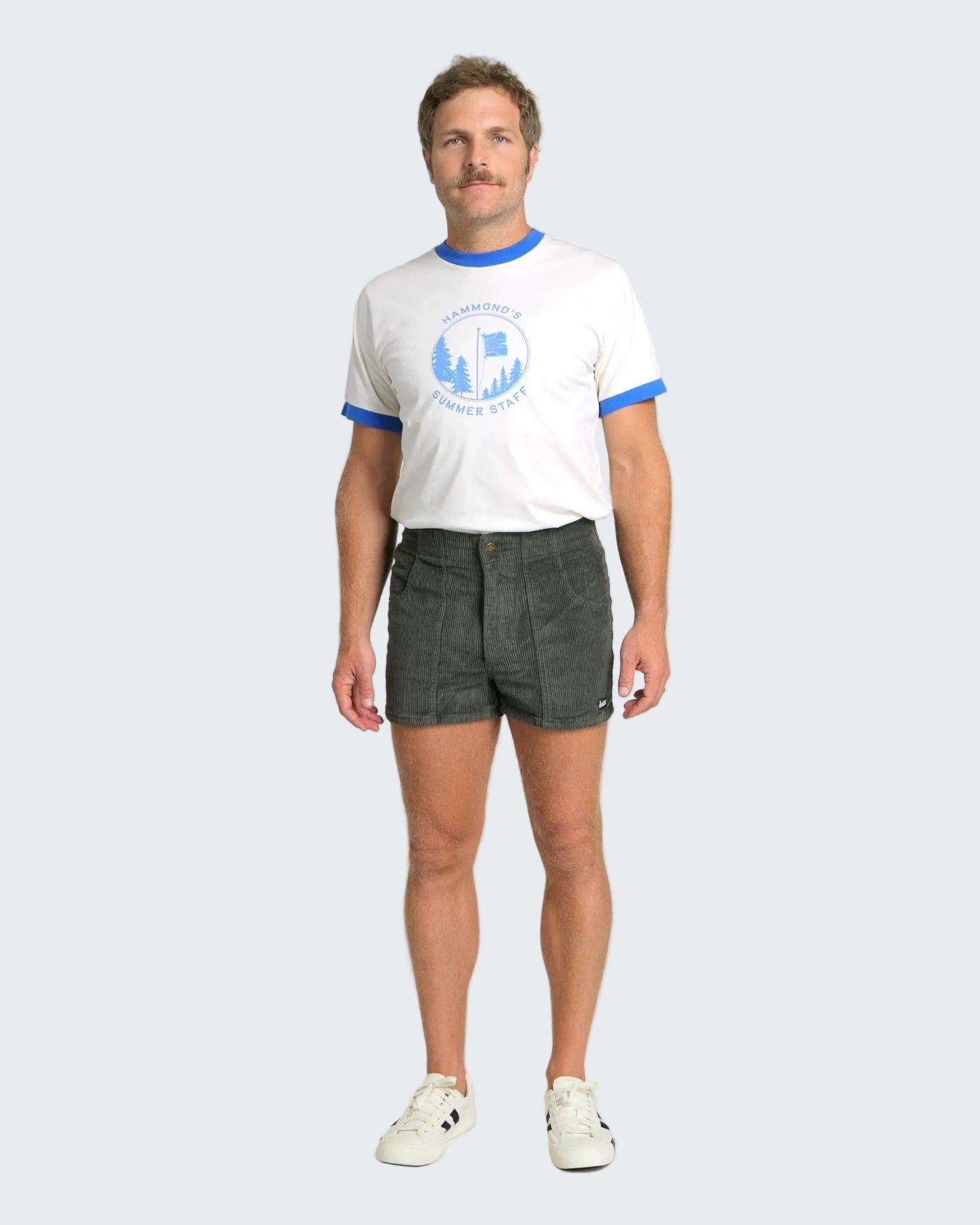 Man wearing a white t-shirt with blue accents and gray shorts on a white background