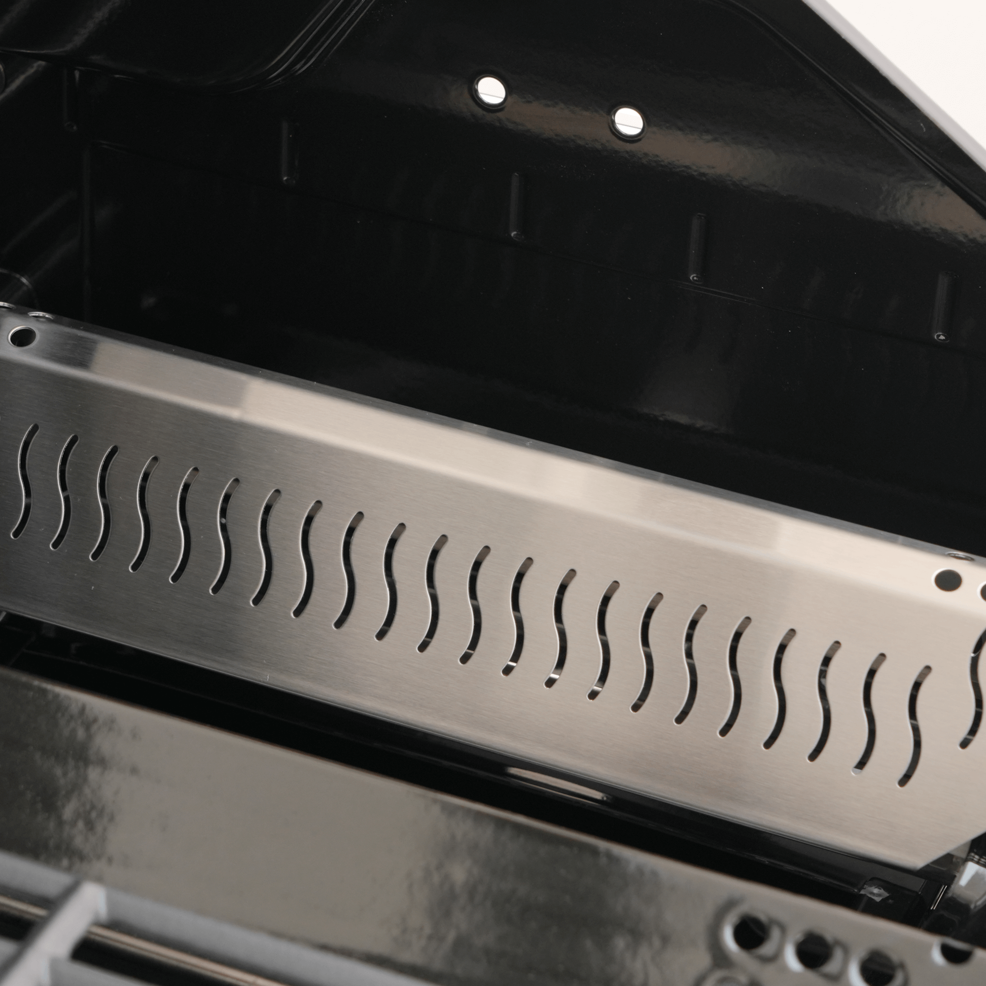 Metal grill grate with wavy pattern inside an oven