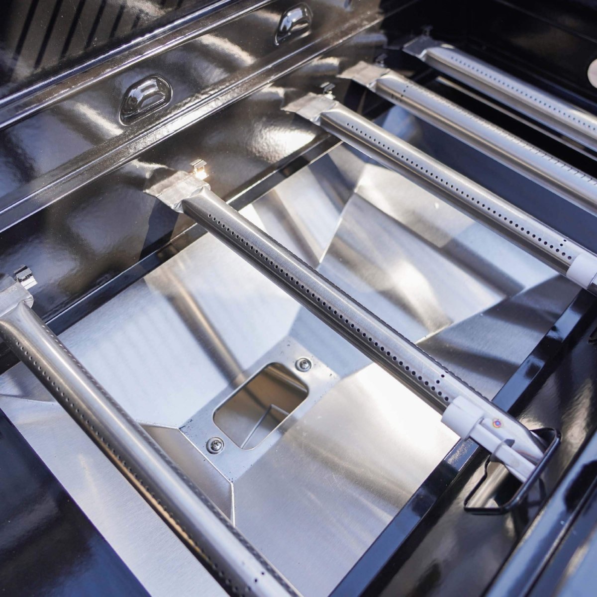 Close-up of a stainless steel grill with visible brand logo.