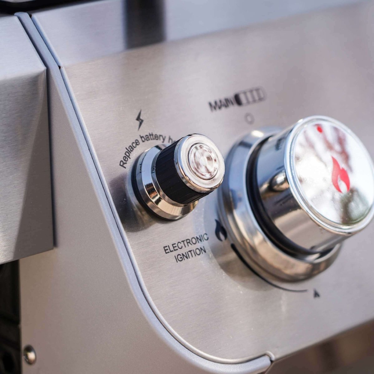 Close-up of a gas grill control panel with electronic ignition and brand logo.