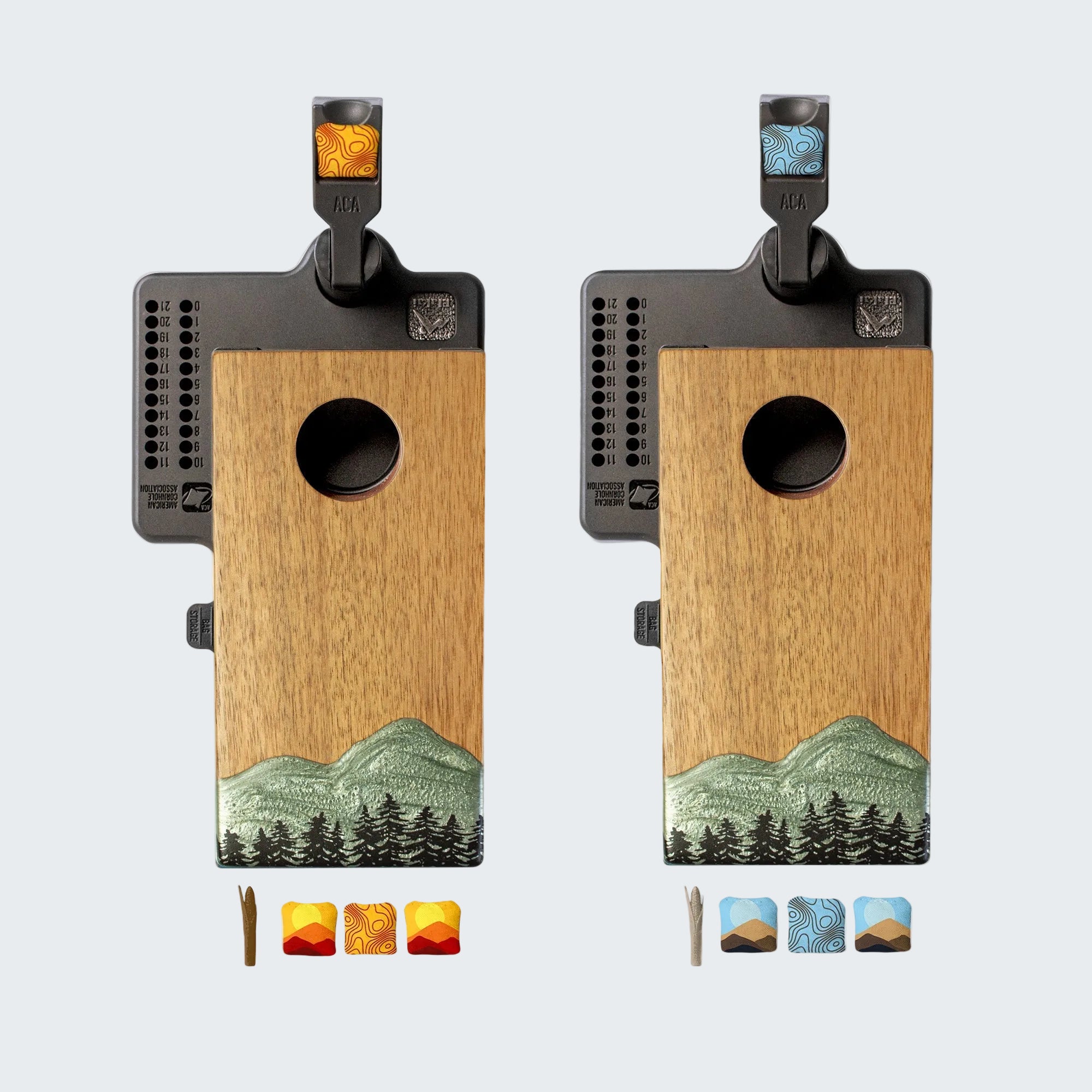 Two wooden birdhouses with mountain and forest design on a white background