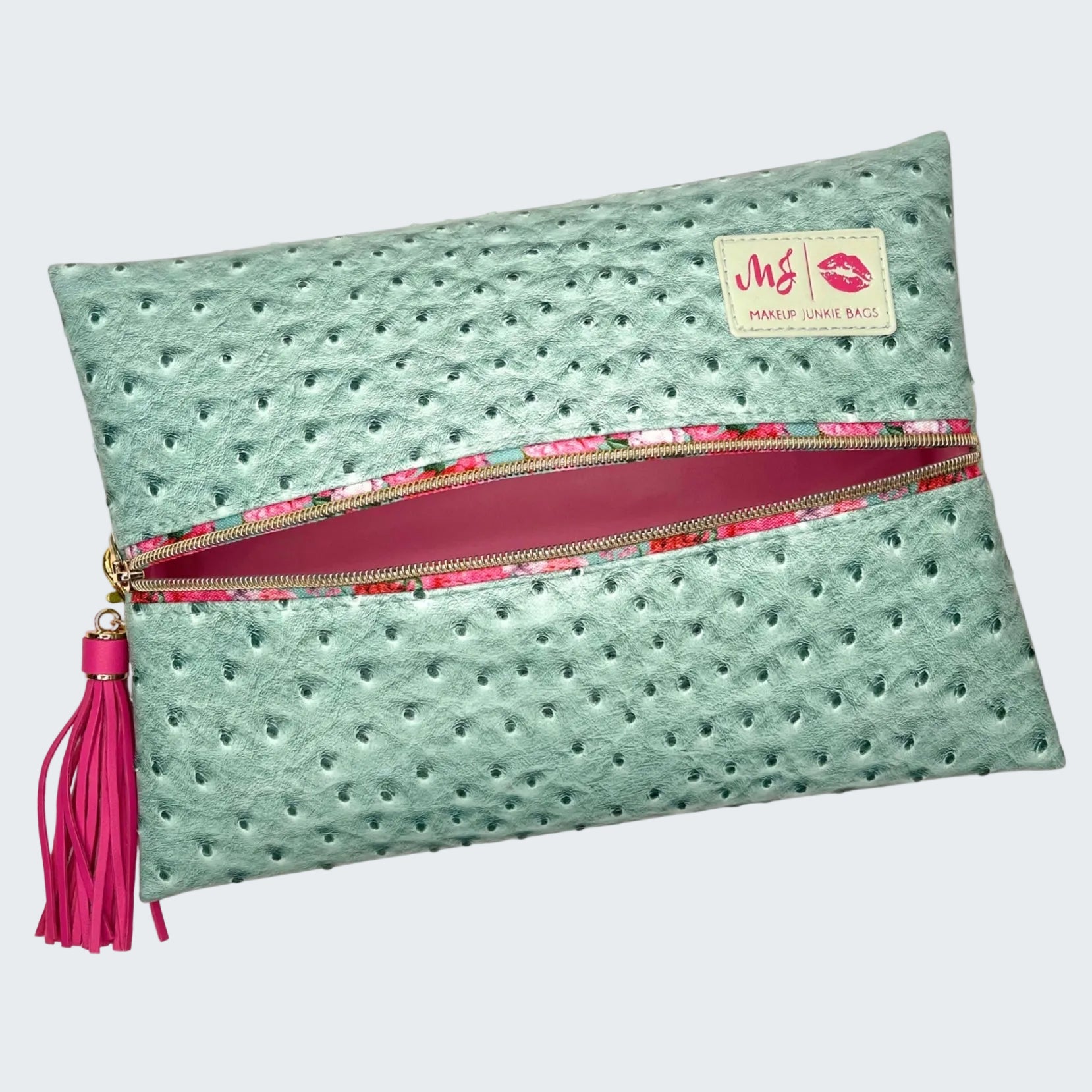 Mint green clutch bag with pink zipper and tassel on a white background
