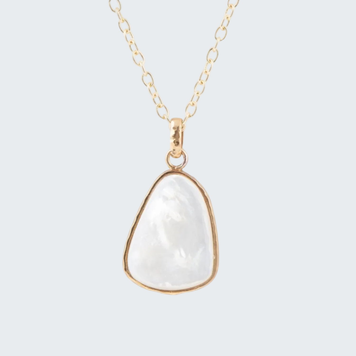 Necklace with a white pendant on a gold chain against a white background