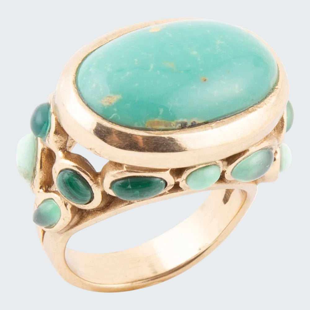 Gold ring with a large turquoise stone and smaller green stones on a white background