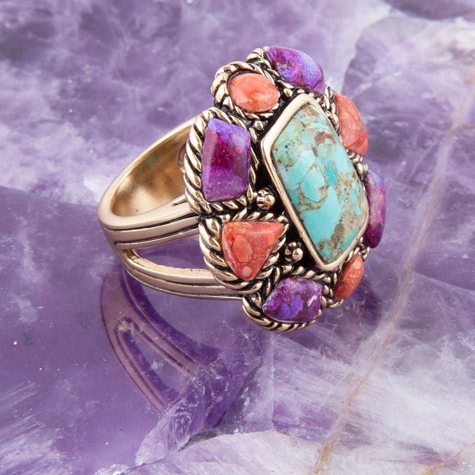 Multicolored gemstone ring on a purple crystal background