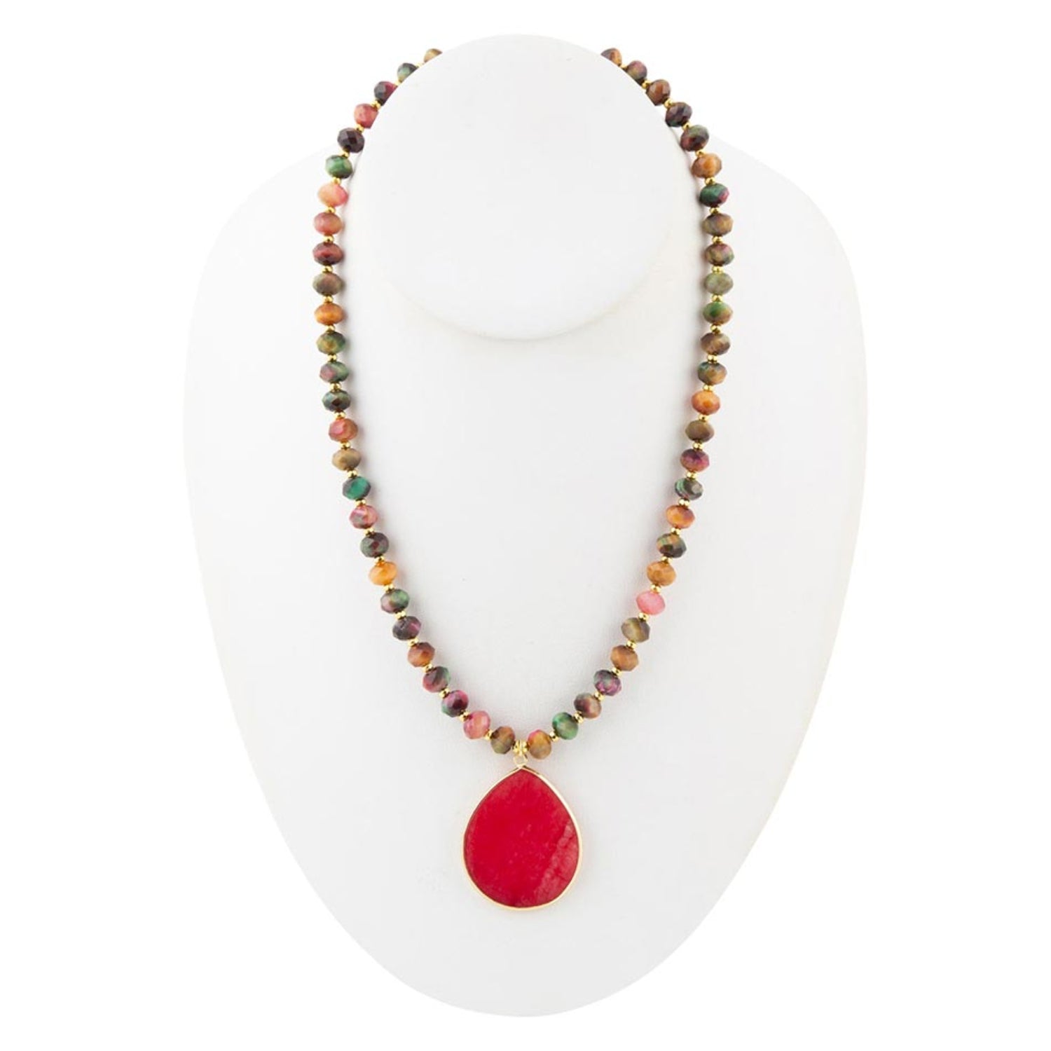Necklace with multicolored beads and a red pendant on a white stand.