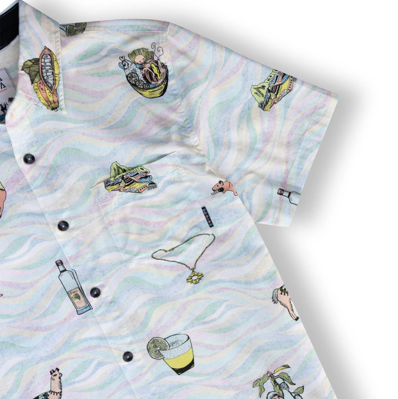 A short-sleeve button-up shirt with a white base and a pastel multicolor wavy pattern, decorated with various illustrated objects including a bottle, cocktail glass, llama, and a hat.