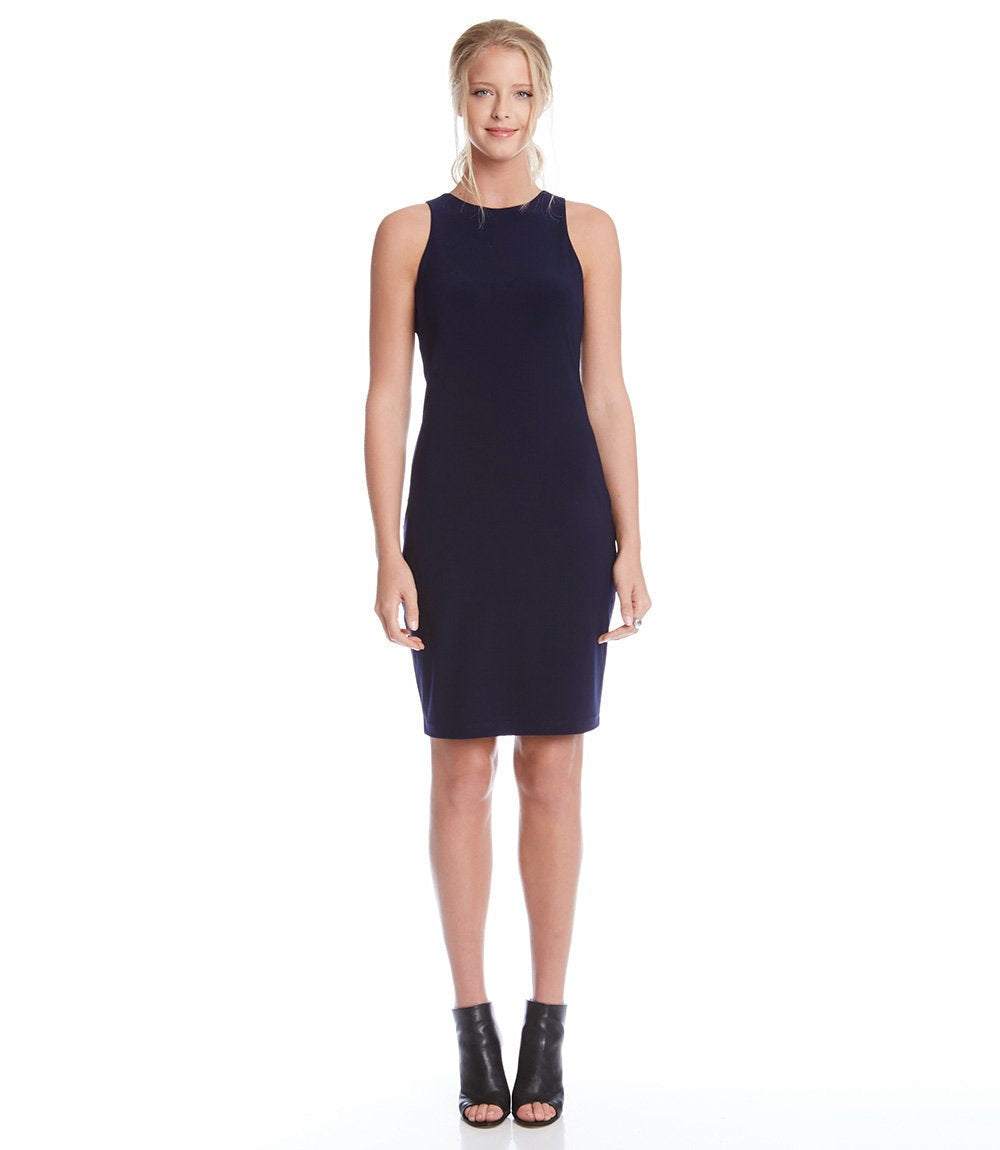 A woman modeling a sleeveless, knee-length navy blue ribbed knit dress against a plain white background.