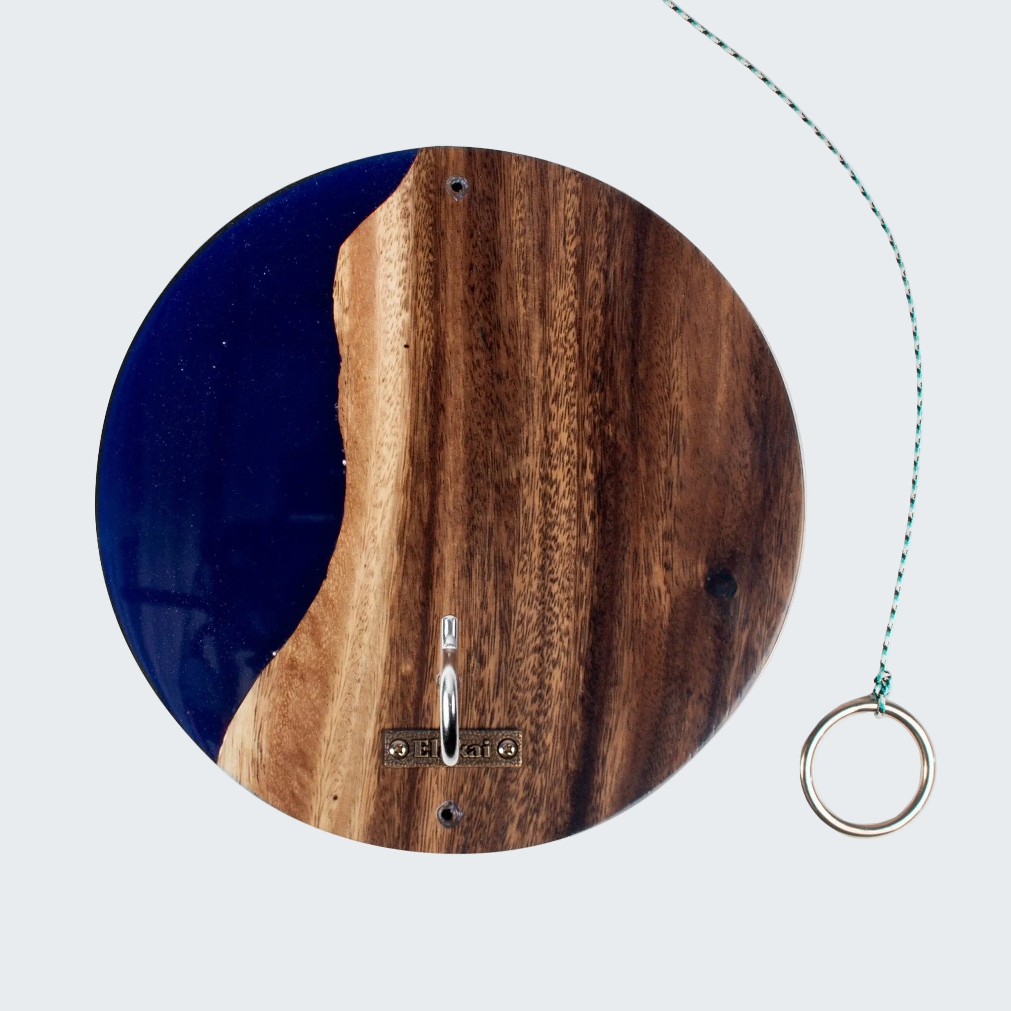A round wooden and resin wall art piece featuring a natural wood grain pattern with a deep blue river-like section, shown on a white background with a hanging ring pull.