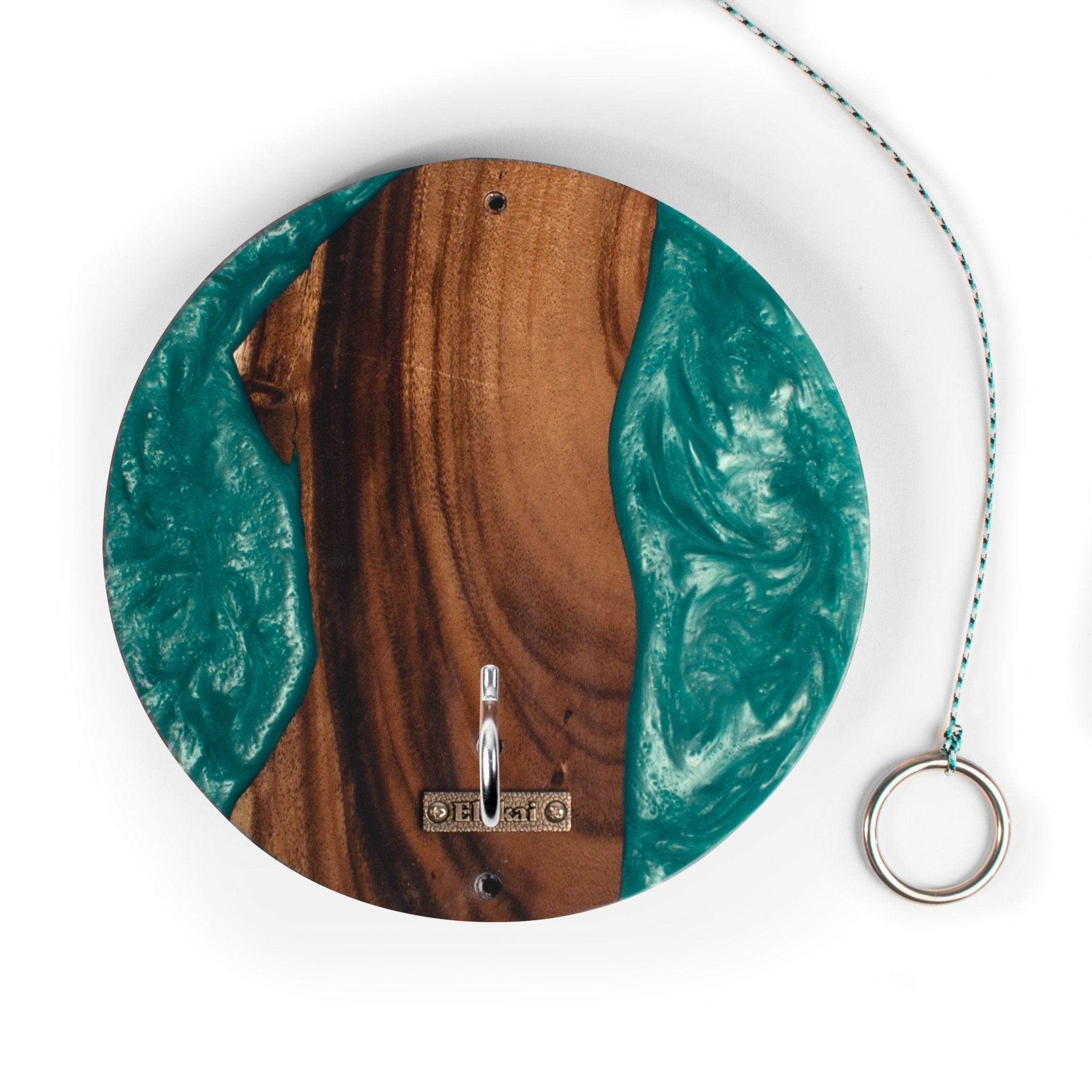A round wall-mounted wooden hook with a natural wood grain center and swirling teal resin edges, shown on a white background with a hanging ring and cord.