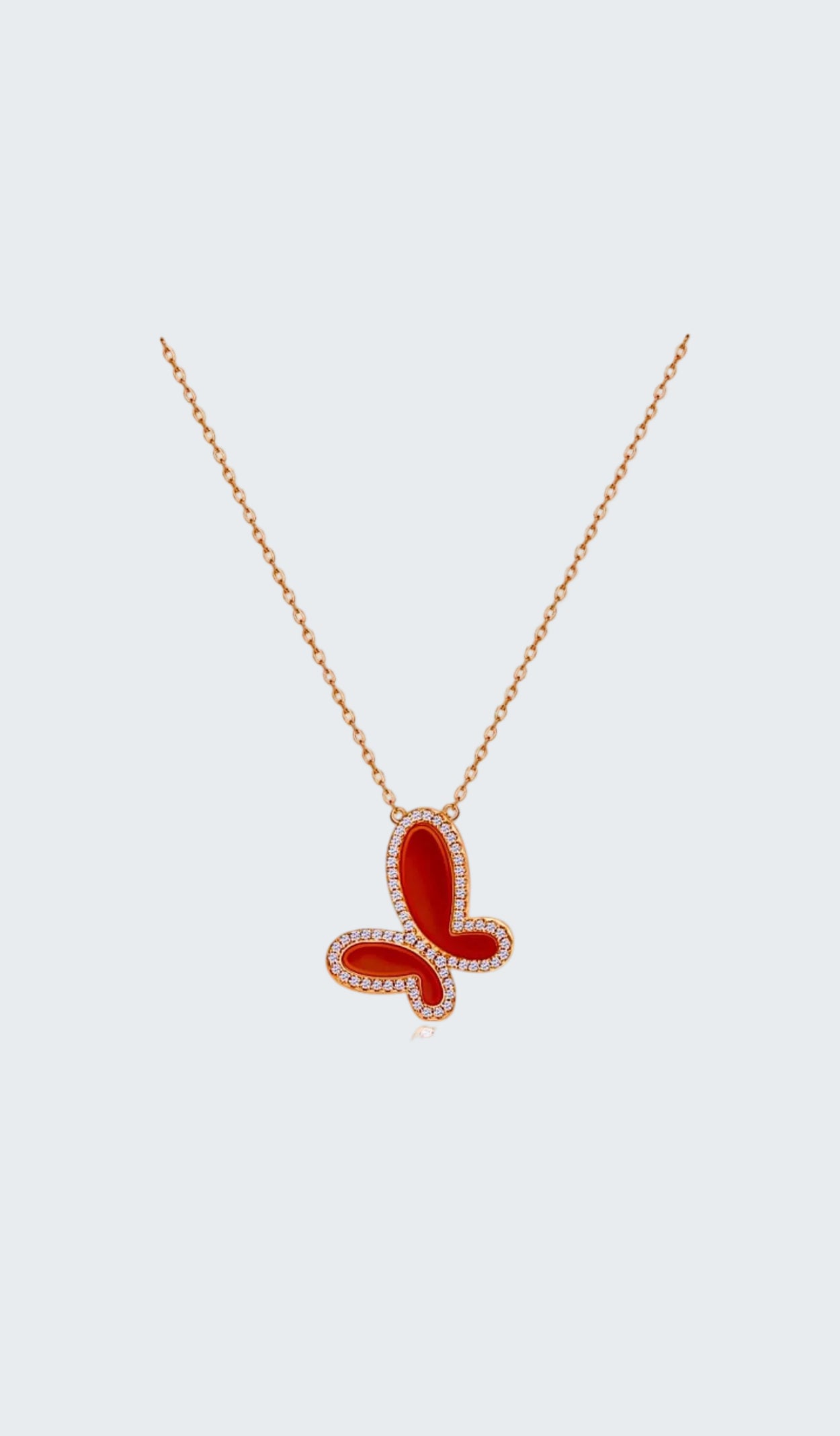 Red butterfly pendant necklace on a white background