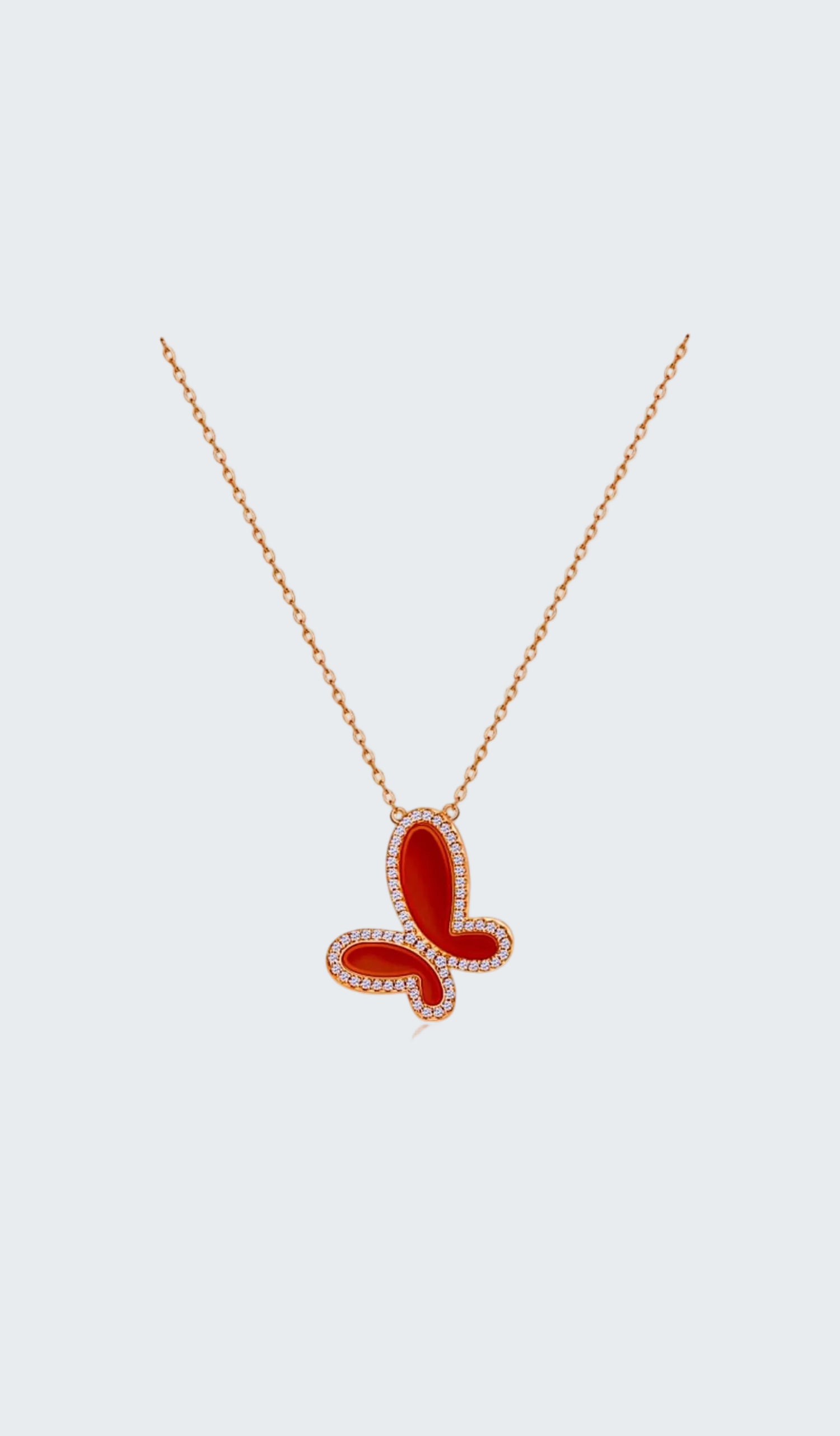 Red butterfly pendant necklace on a white background