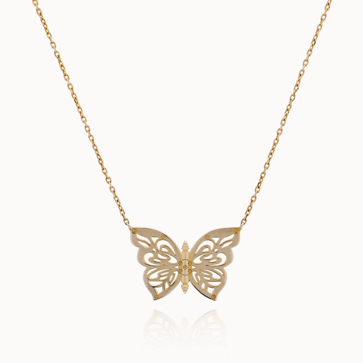Gold butterfly necklace on a white background