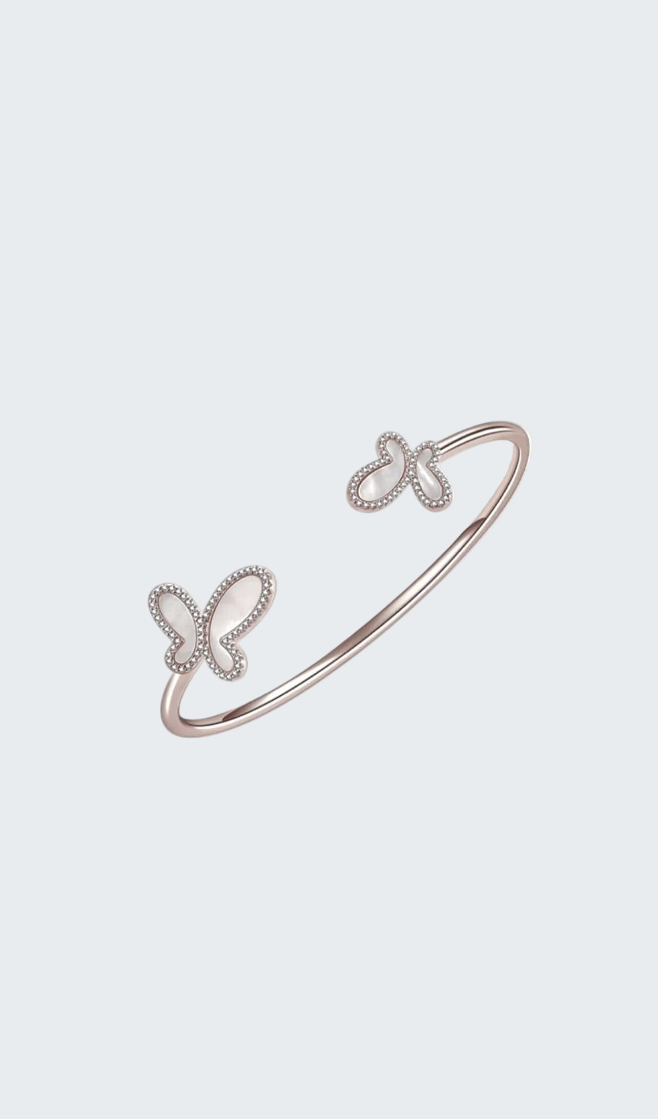 Rose gold bracelet with butterfly designs on a white background