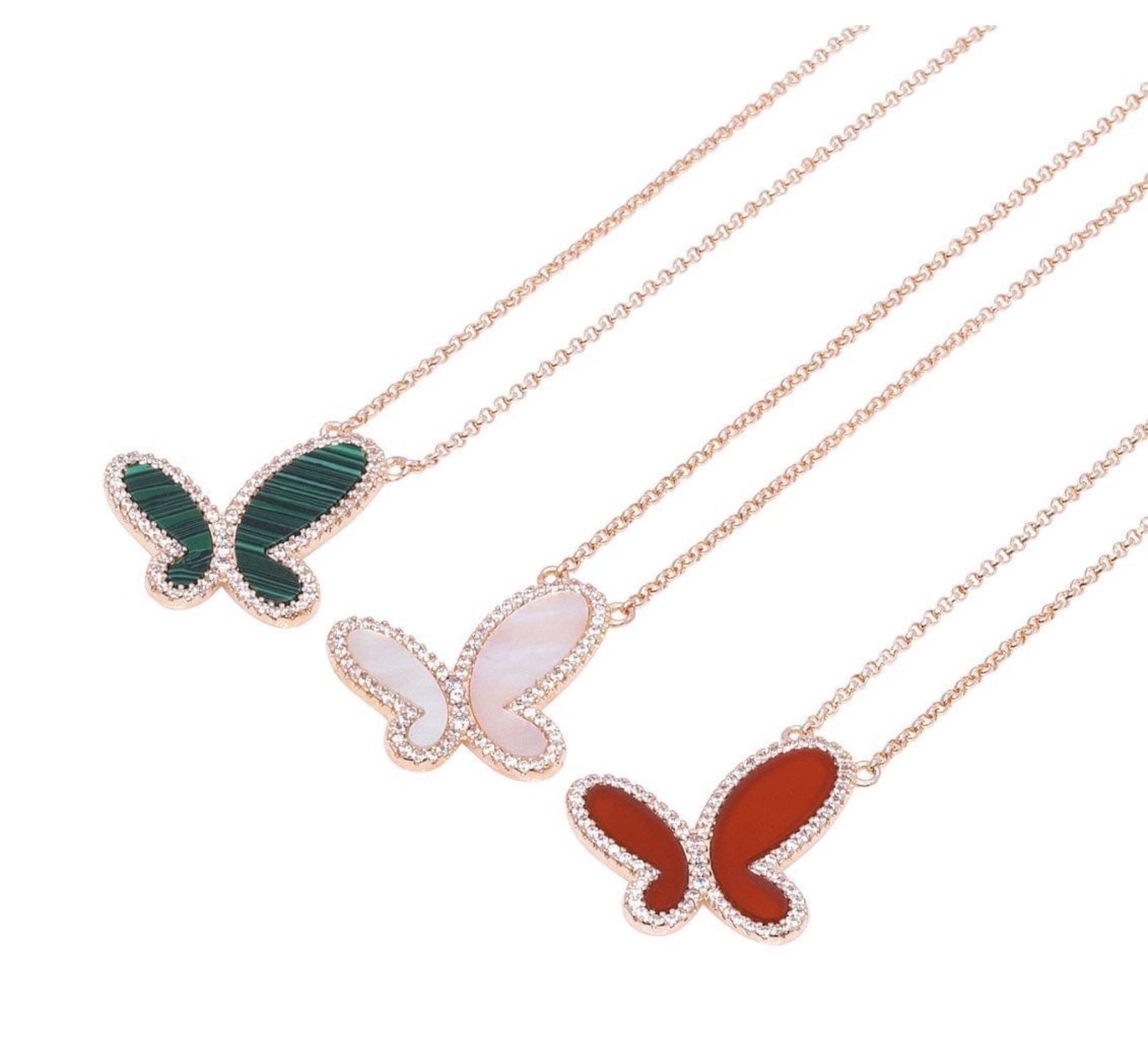 Butterfly-shaped pendants on gold chains against a white background