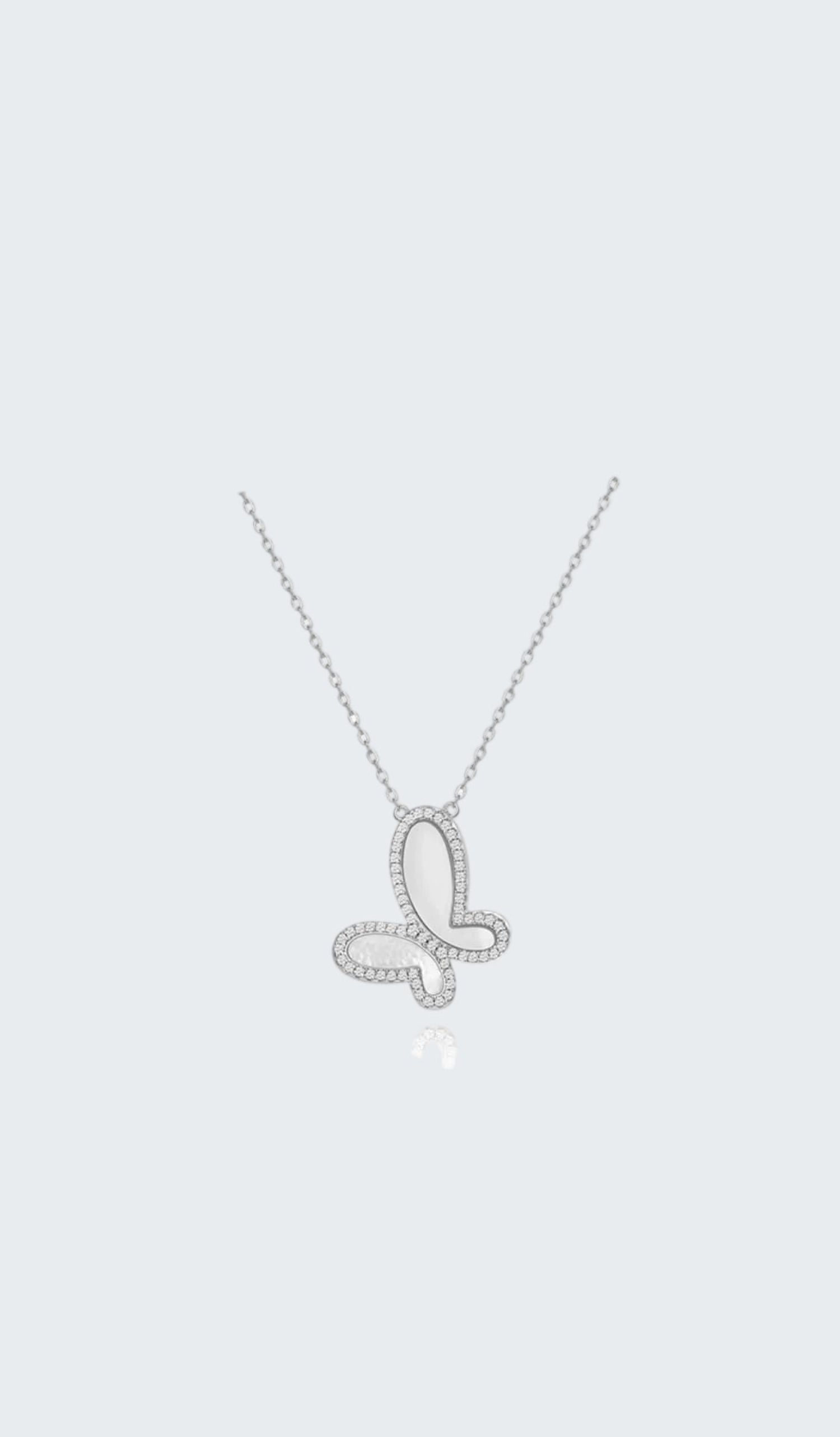 Butterfly-shaped silver necklace on a white background