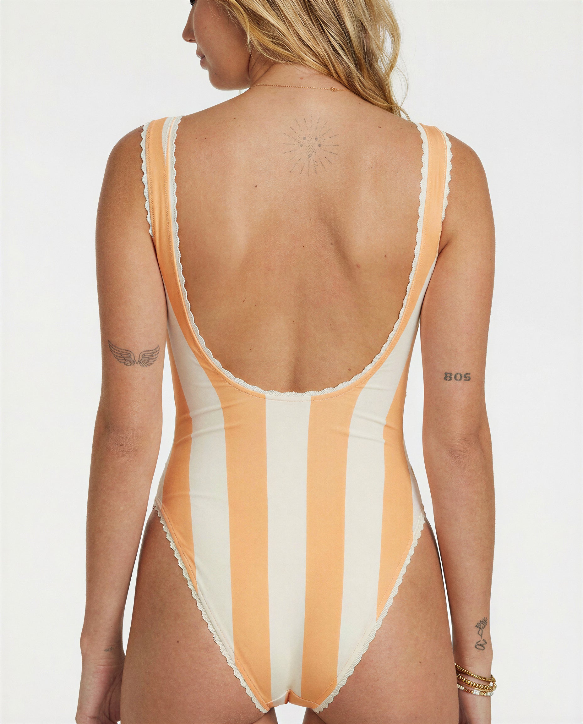 Woman wearing a striped swimsuit with a white background