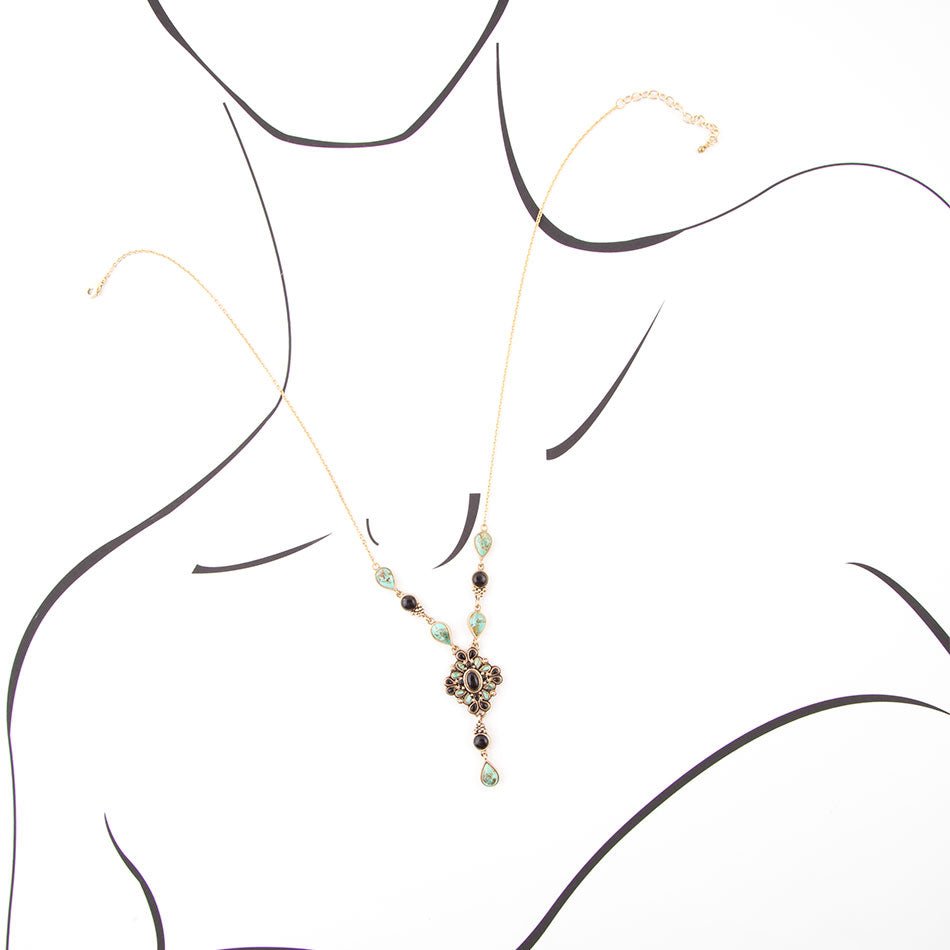 Necklace with green beads and a decorative clasp on a white background