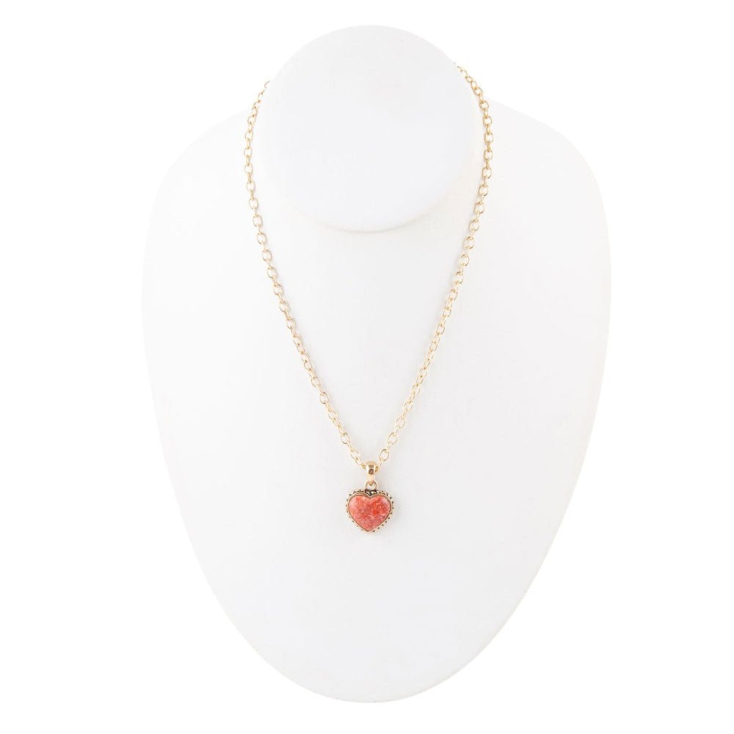 Necklace with a pink heart pendant on a white stand