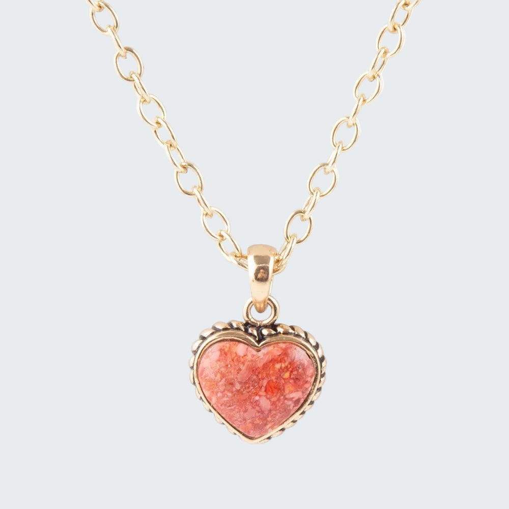 Necklace with a heart-shaped pink pendant on a gold chain against a white background