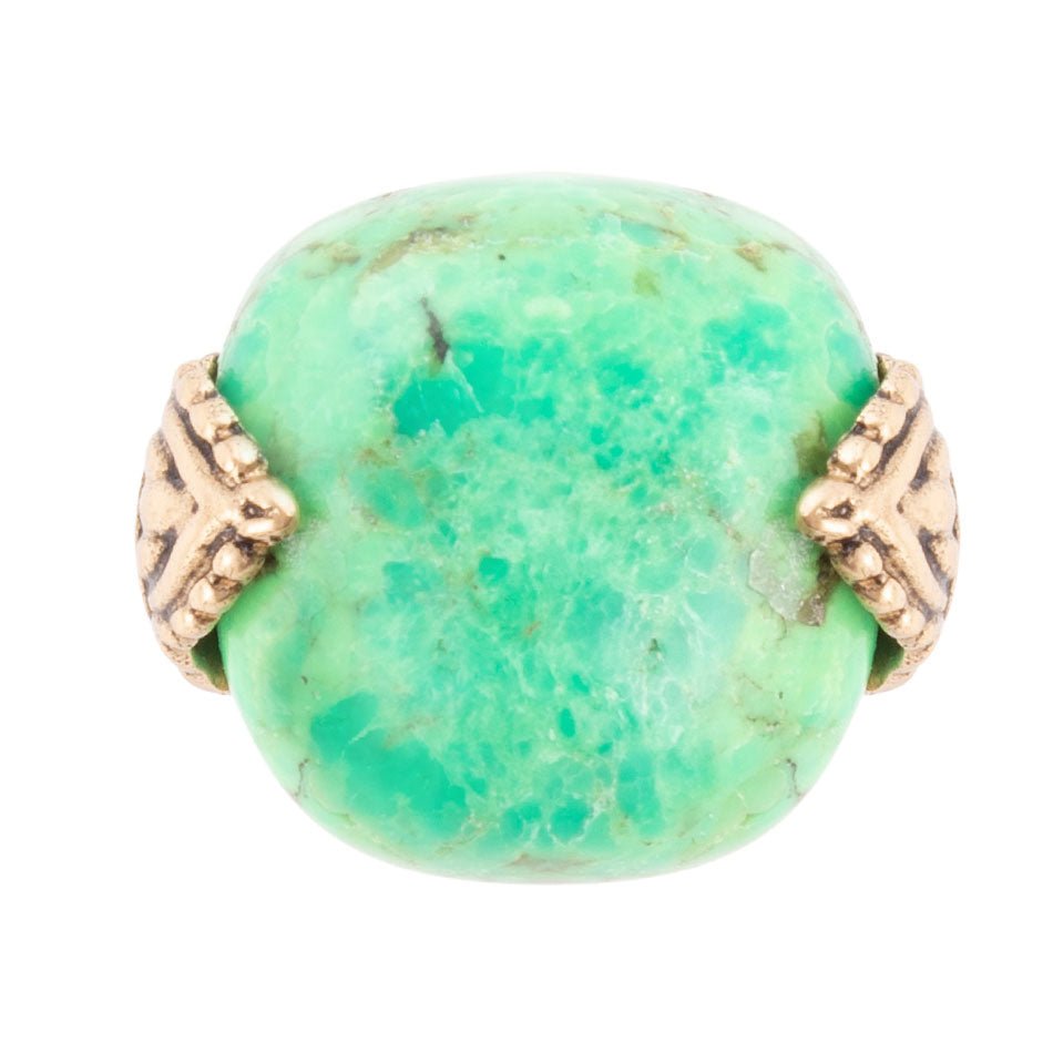 Turquoise stone ring with gold accents on a white background
