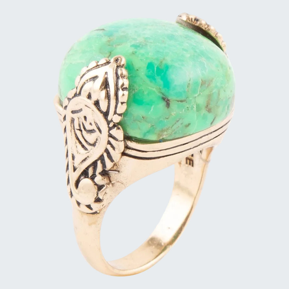 Ring with green stone and gold band on a white background