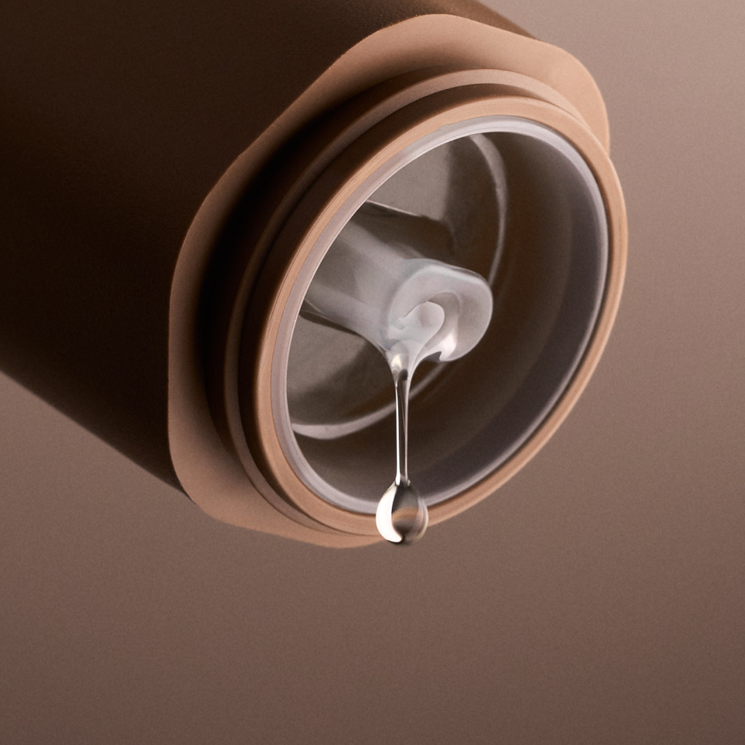 Close-up of a brown coffee filter with a drop of coffee on a brown background